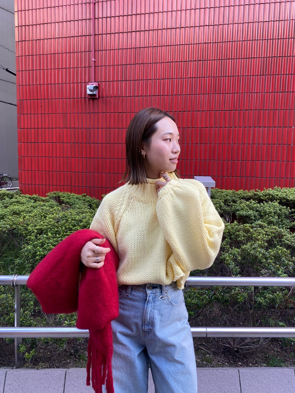 ブルー系のデニムパンツ、イエロー系のニット/セーター、ブラウン系のブーツを着用したレディースの秋コーディネートの5枚目の写真