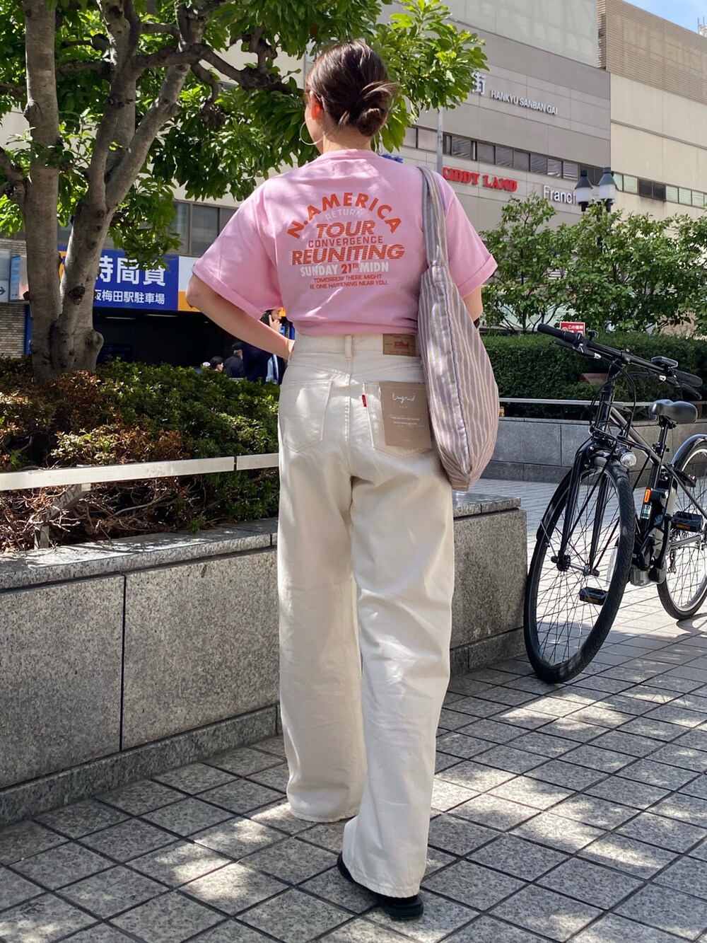 ホワイト系のデニムパンツ、ピンク系のTシャツ/カットソー、ブラック系のサンダルを着用したレディースの春コーディネートの3枚目の写真