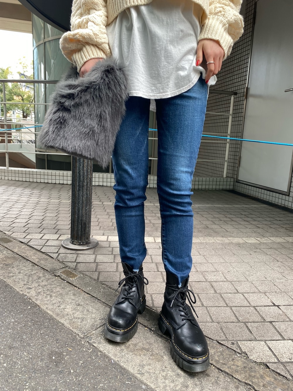 ホワイト系のニット/セーター、ホワイト系のTシャツ/カットソー、ブルー系のデニムパンツを着用したレディースの冬コーディネートの5枚目の写真