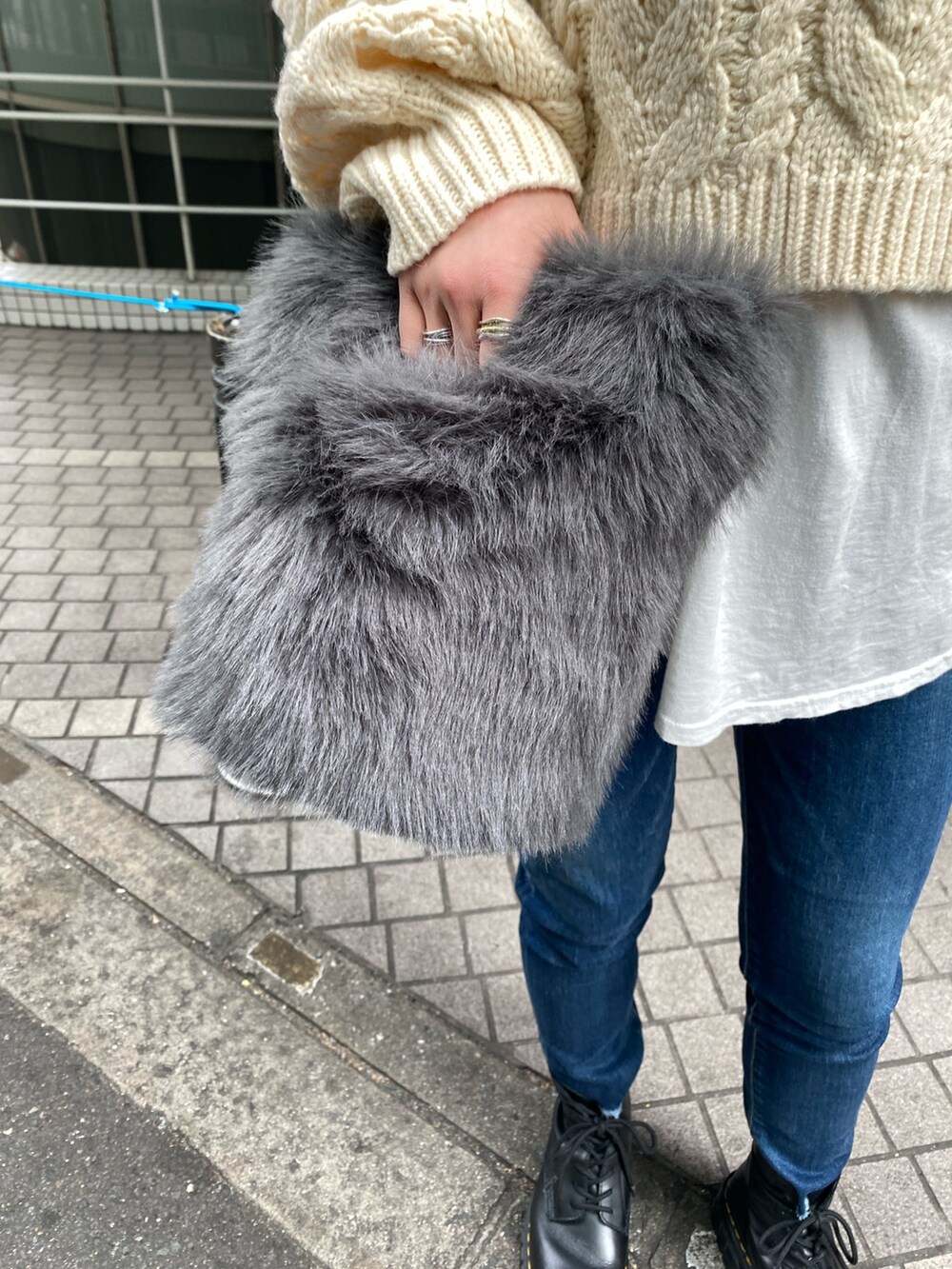 ホワイト系のニット/セーター、ホワイト系のTシャツ/カットソー、ブルー系のデニムパンツを着用したレディースの冬コーディネートの6枚目の写真