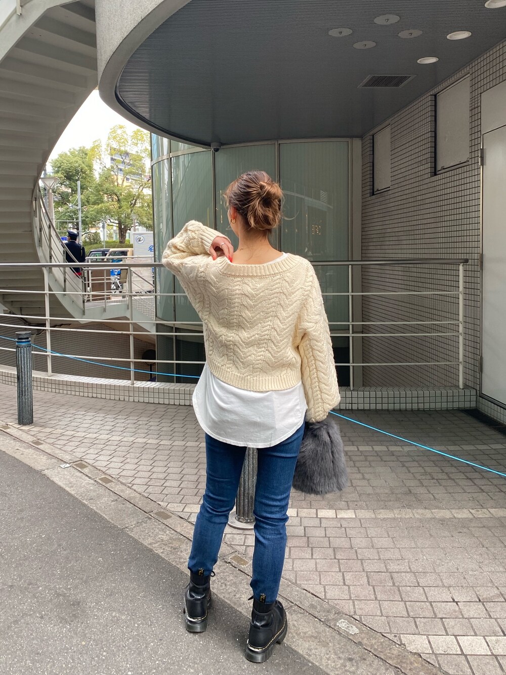 ホワイト系のニット/セーター、ホワイト系のTシャツ/カットソー、ブルー系のデニムパンツを着用したレディースの冬コーディネートの4枚目の写真