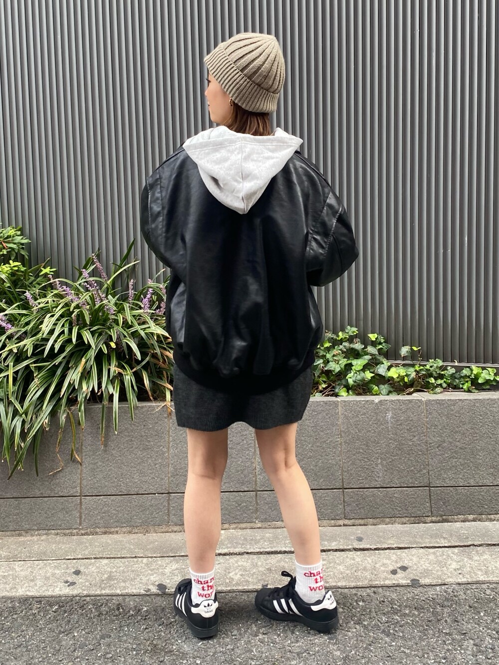 グレー系のスカート、ブラック系のブルゾン、グレー系のパーカーを着用したレディースの秋コーディネートの3枚目の写真