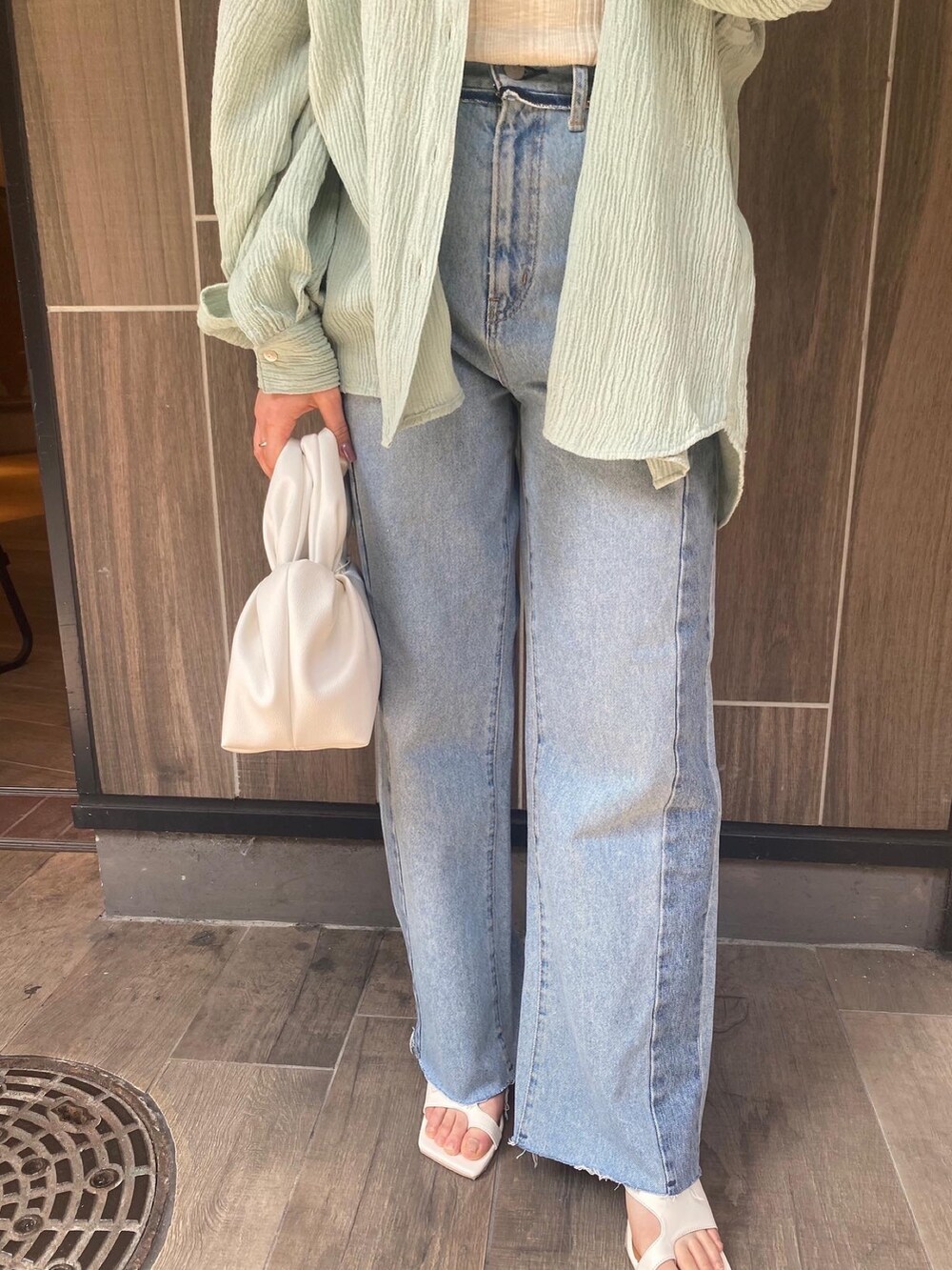 グリーン系のシャツ/ブラウス、ブルー系のデニムパンツ、ホワイト系のハンドバッグを着用したレディースの春コーディネートの5枚目の写真