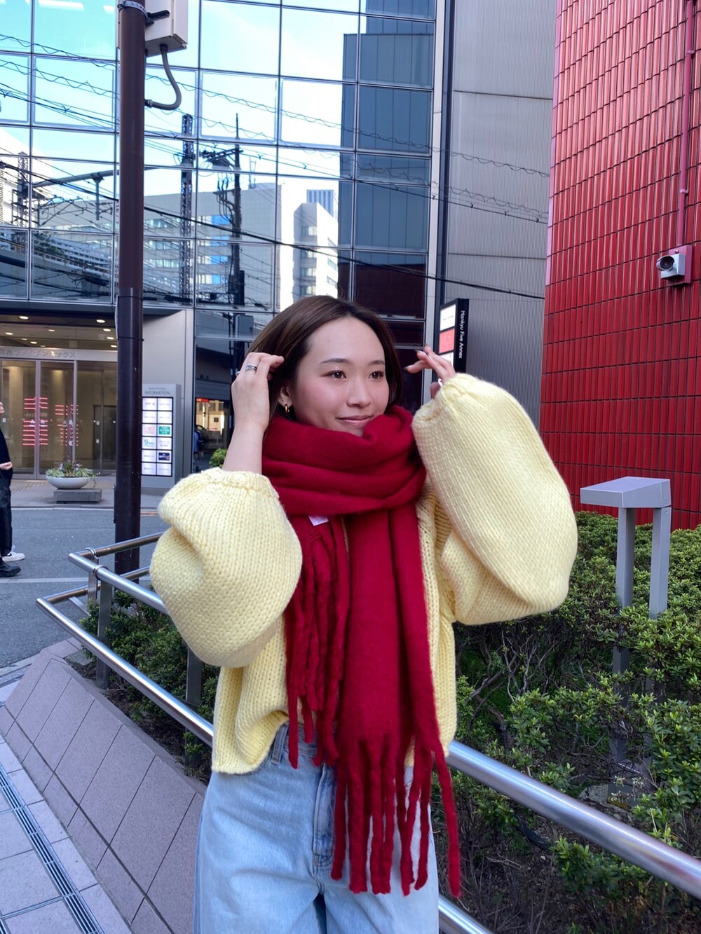 ブルー系のデニムパンツ、イエロー系のニット/セーター、ブラウン系のブーツを着用したレディースの秋コーディネートの4枚目の写真