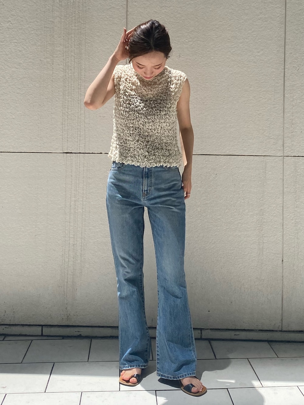 ブルー系のデニムパンツ、ホワイト系のシャツ/ブラウス、ブラック系のサンダルを着用したレディースの夏コーディネートの2枚目の写真