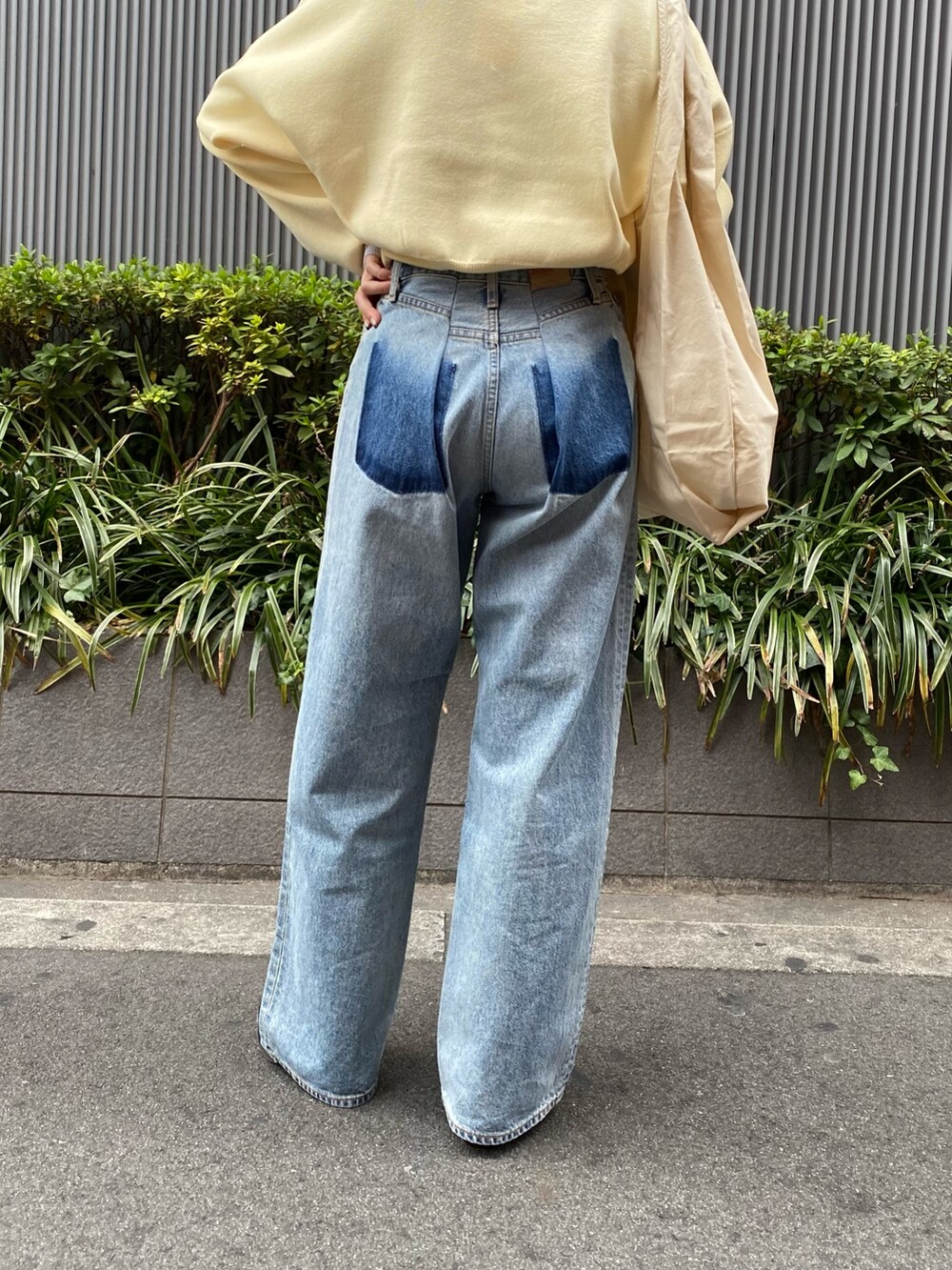 ブルー系のデニムパンツ、ブラック系のブーツ、イエロー系のニット/セーターを着用したレディースの冬コーディネートの5枚目の写真