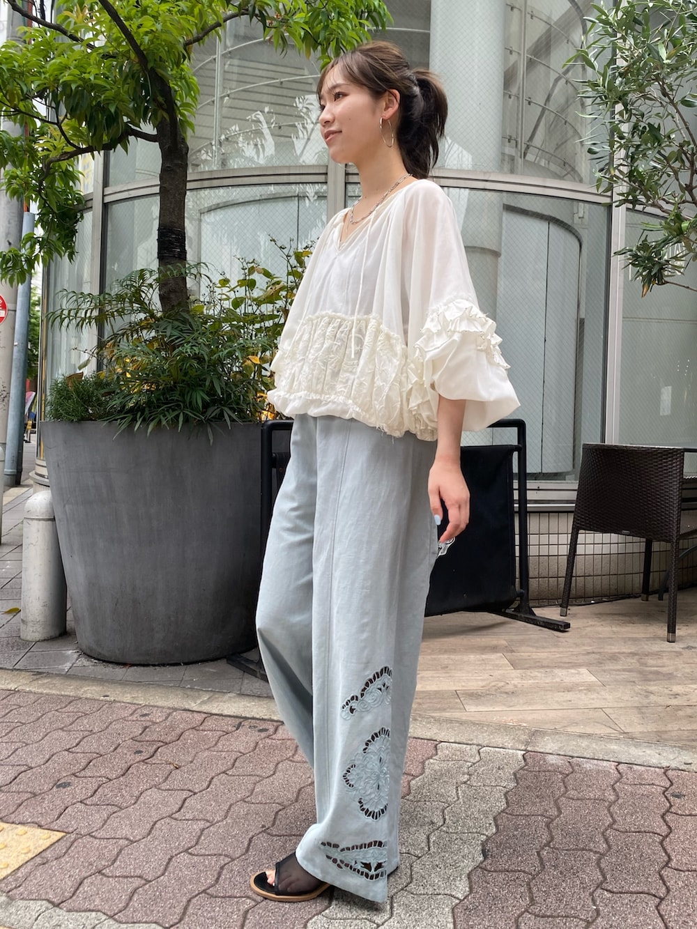 ブルー系のその他パンツ、ブラック系のサンダル、ホワイト系のシャツ/ブラウスを着用したレディースの春コーディネートの2枚目の写真