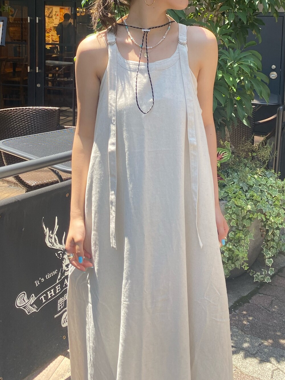 ホワイト系のワンピース、ブルー系のデニムパンツ、ベージュ系のハットを着用したレディースの夏コーディネートの2枚目の写真