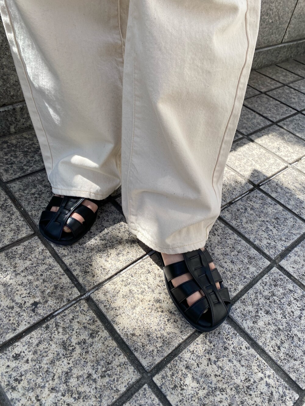 ホワイト系のデニムパンツ、ピンク系のTシャツ/カットソー、ブラック系のサンダルを着用したレディースの春コーディネートの7枚目の写真