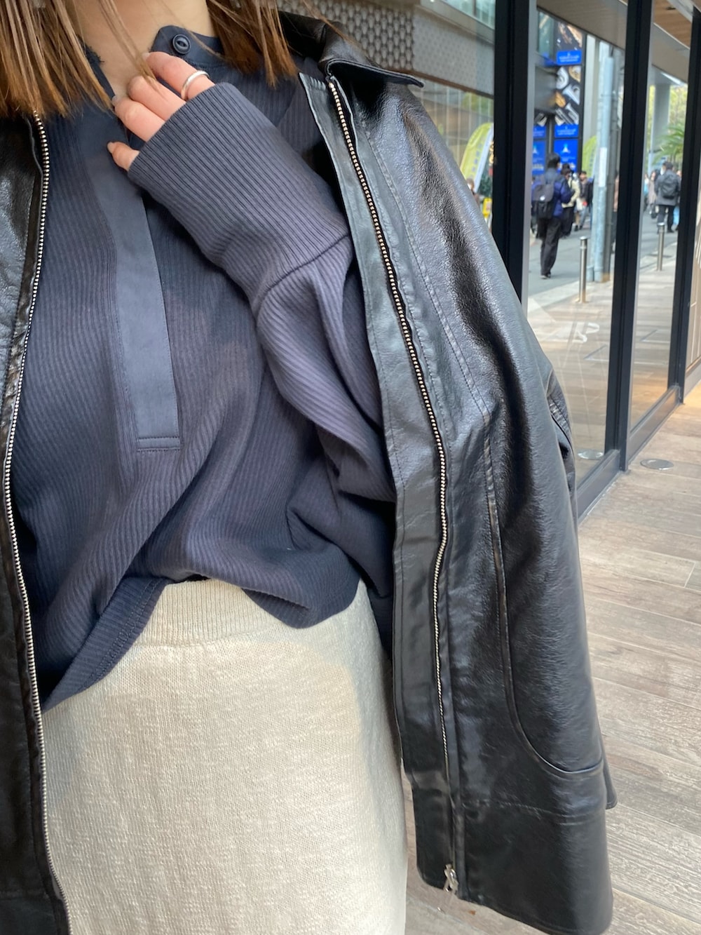 ホワイト系のスカート、ブラック系のブルゾン、グレー系のTシャツ/カットソーを着用したレディースの冬コーディネートの6枚目の写真