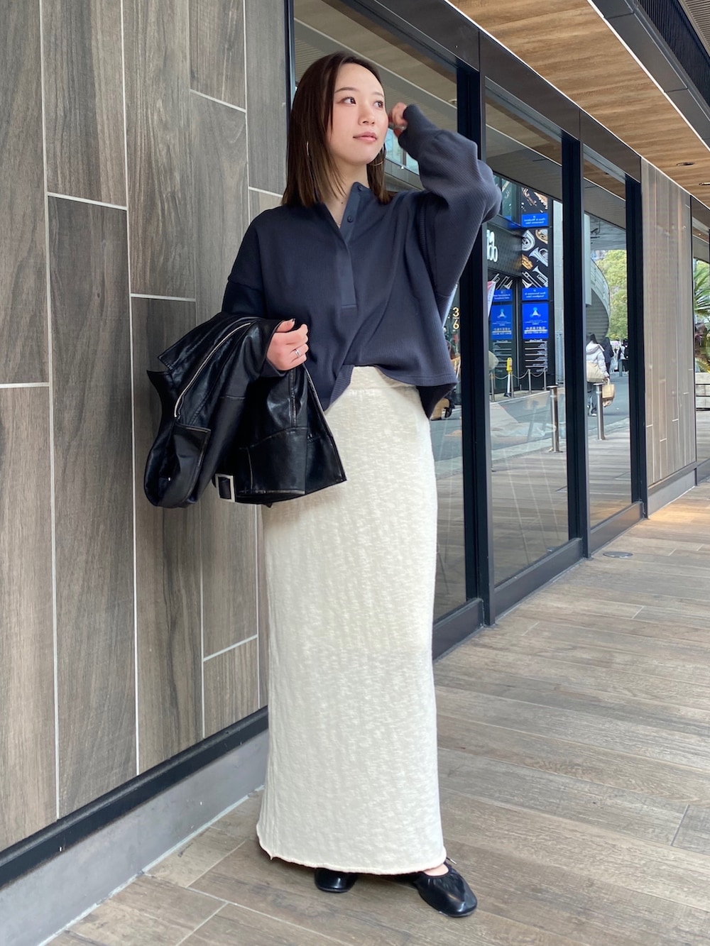 ホワイト系のスカート、ブラック系のブルゾン、グレー系のTシャツ/カットソーを着用したレディースの冬コーディネートの5枚目の写真