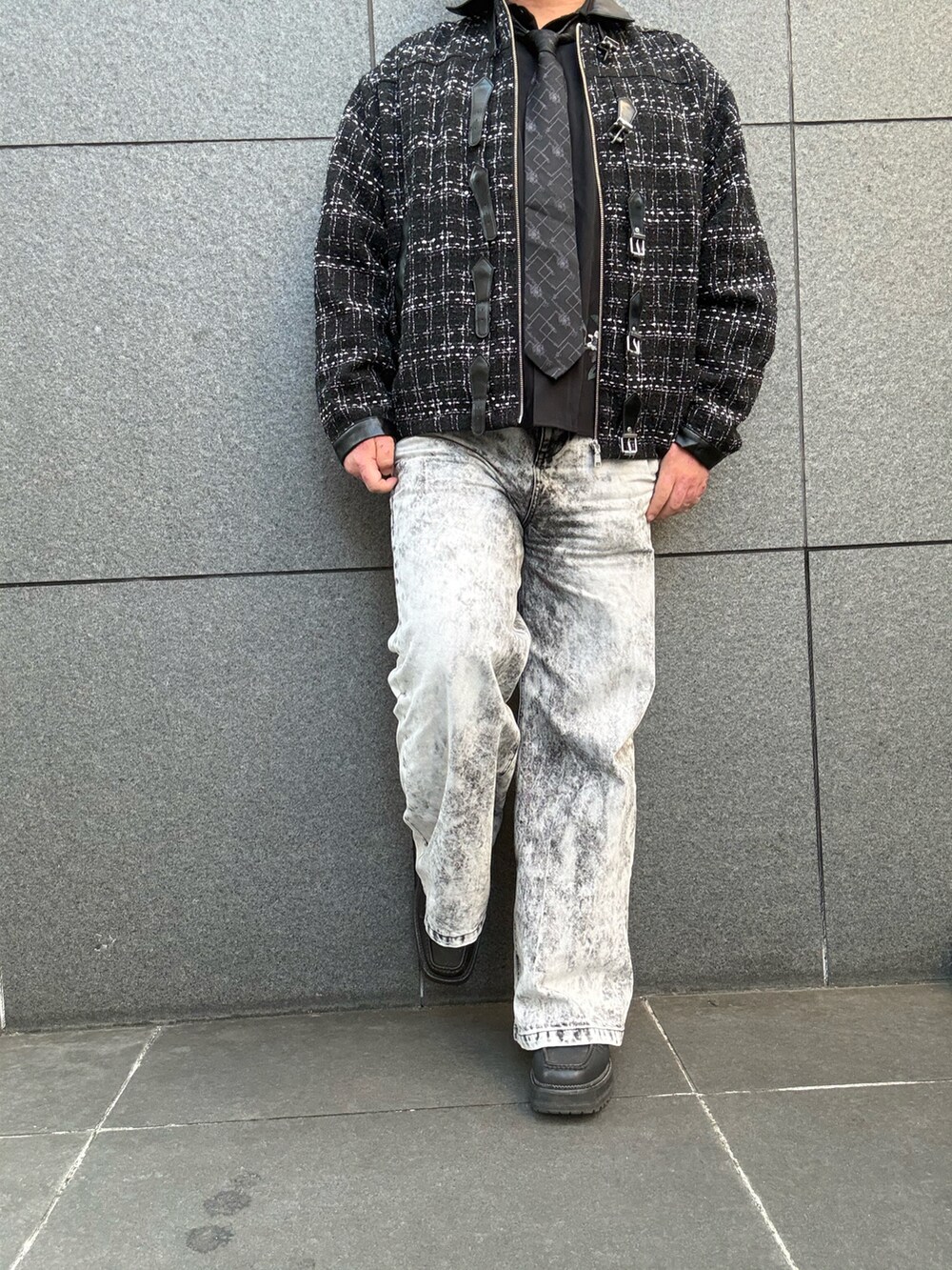ブラック系のデニムパンツ、ブラック系のブーツ、ブラック系のブルゾンを着用したメンズの秋コーディネートの4枚目の写真
