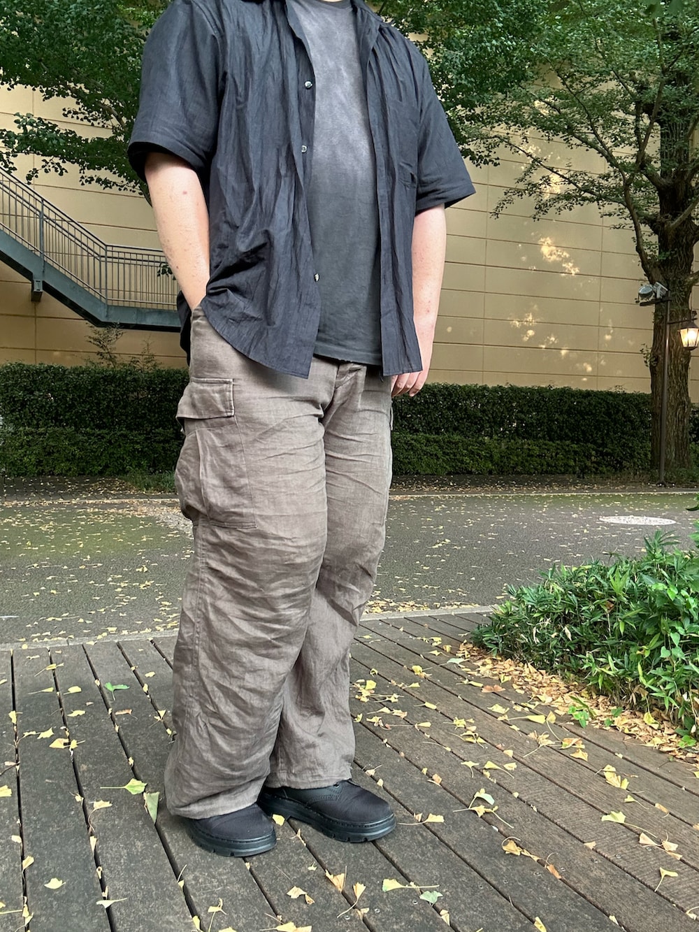 グリーン系のカーゴパンツ、ブルー系のシャツ/ブラウス、ブラック系のTシャツ/カットソーを着用したメンズの夏コーディネートの2枚目の写真