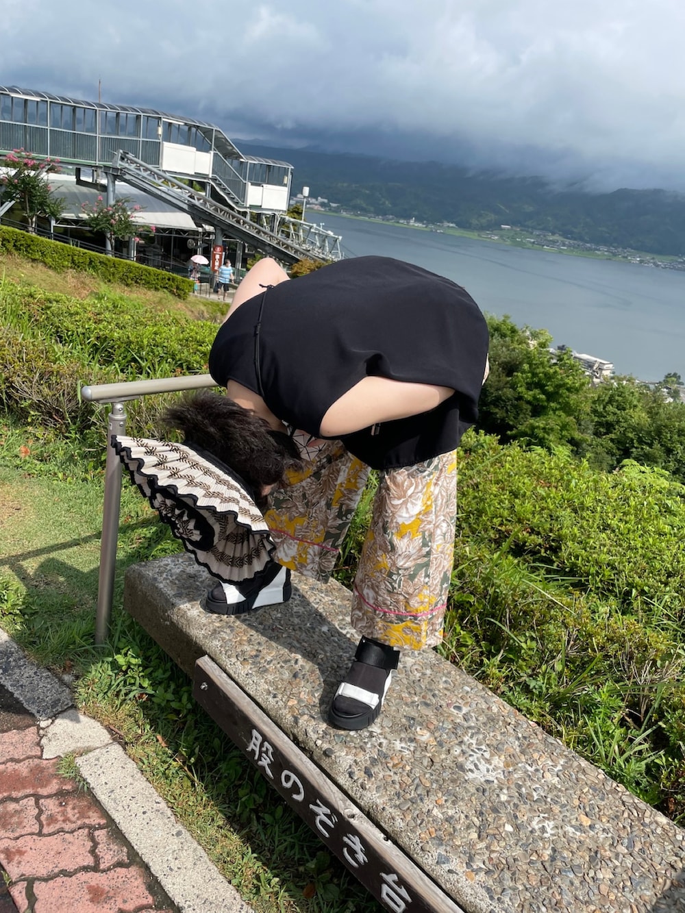 ブラック系のタンクトップ、イエロー系のパンツ、ホワイト系のショルダーバッグを着用したレディースの春コーディネートの3枚目の写真