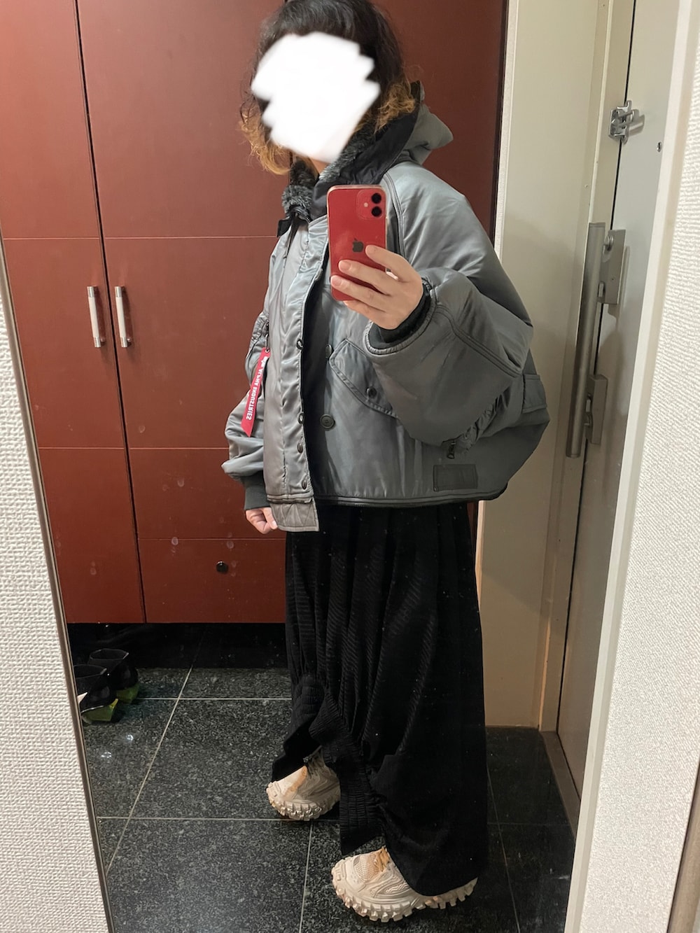 ブラック系のショルダーバッグ、ブラック系のスカート、ベージュ系のスニーカーを着用したレディースの秋コーディネートの3枚目の写真