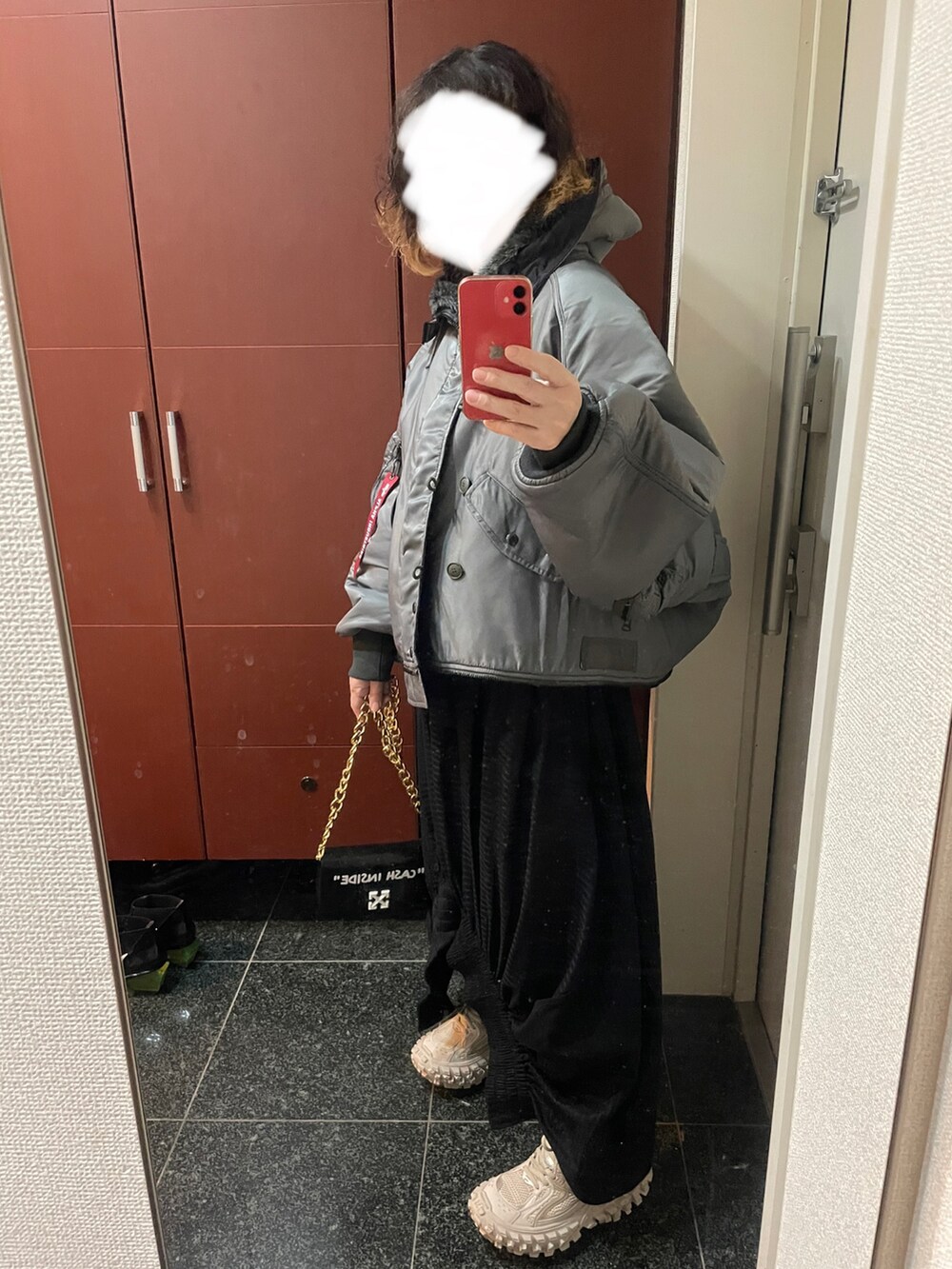 ブラック系のショルダーバッグ、ブラック系のスカート、ベージュ系のスニーカーを着用したレディースの秋コーディネートの2枚目の写真