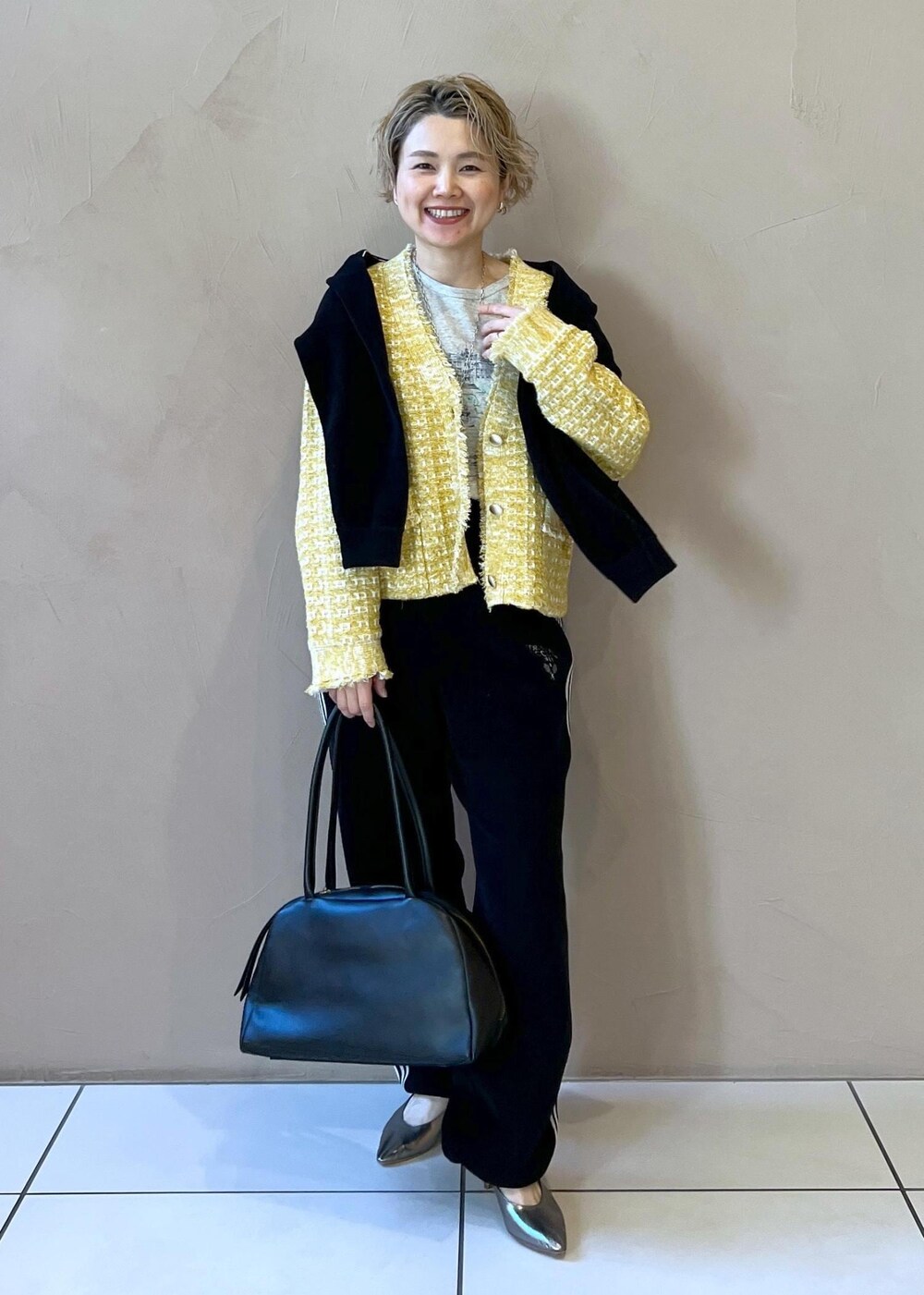 イエロー系のカーディガン/ボレロ、ブラック系のカーディガン/ボレロ、グレー系のTシャツ/カットソーを着用したレディースの冬コーディネートの9枚目の写真