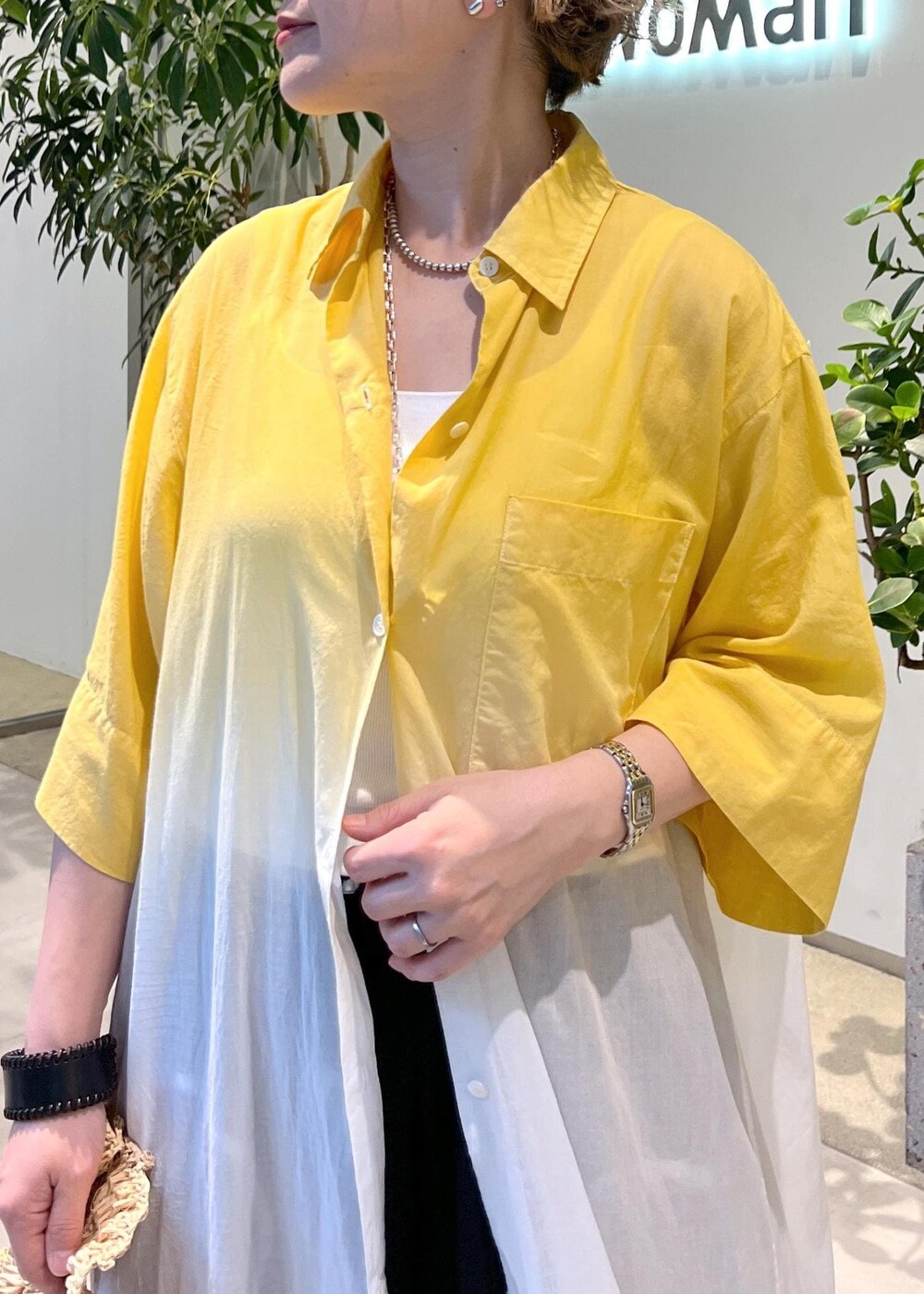 ブラック系のサンダル、ホワイト系のハンドバッグを着用したレディースの夏コーディネートの7枚目の写真