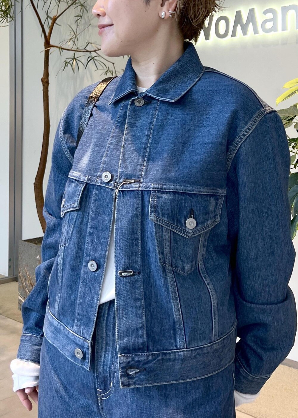 ブラック系のショルダーバッグ、ブルー系のデニムジャケット、ブルー系のデニムパンツを着用したレディースの秋コーディネートの7枚目の写真