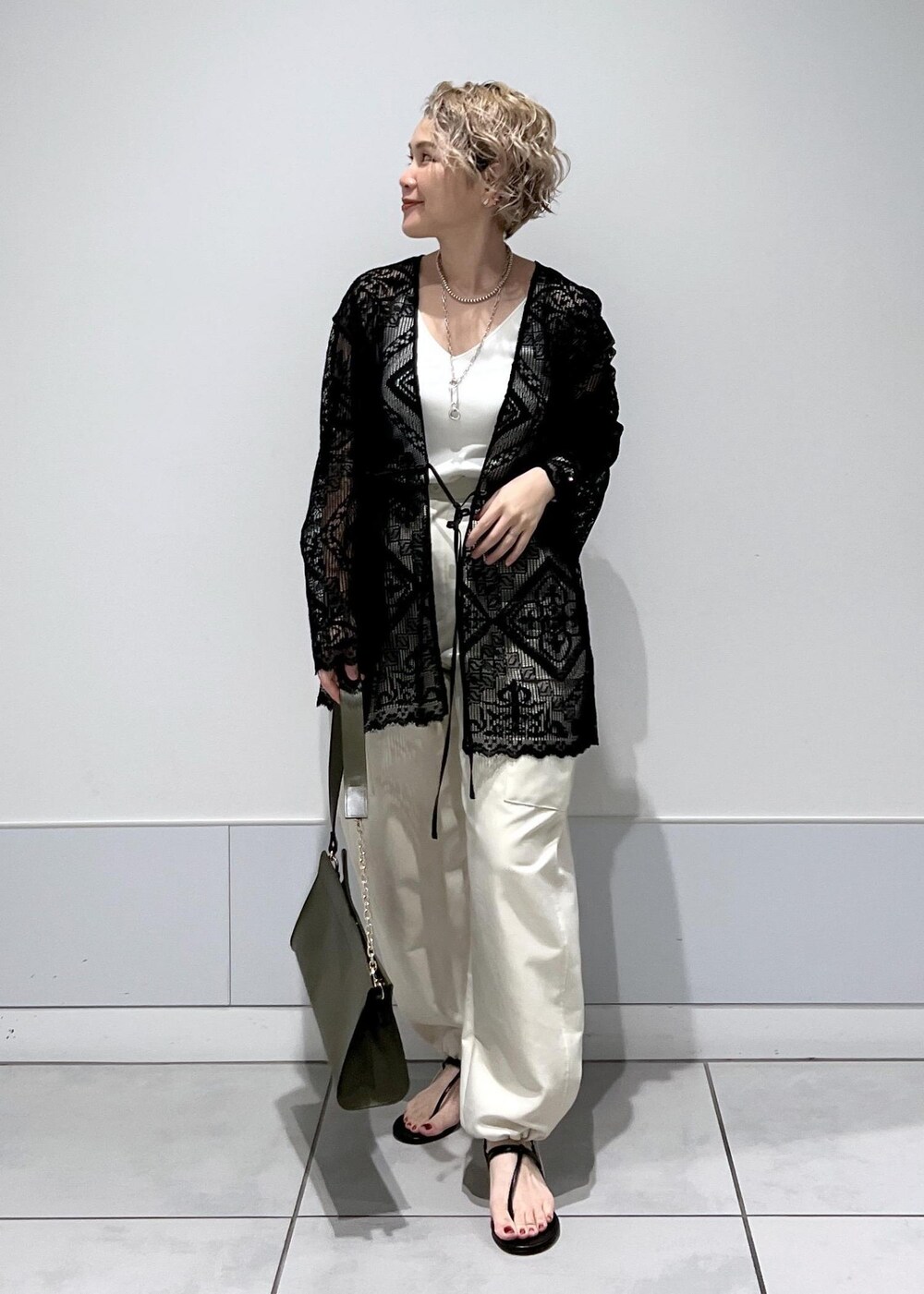 ホワイト系のカーゴパンツ、ホワイト系のキャミソール、ブラック系のノーカラージャケットを着用したレディースの夏コーディネートの2枚目の写真