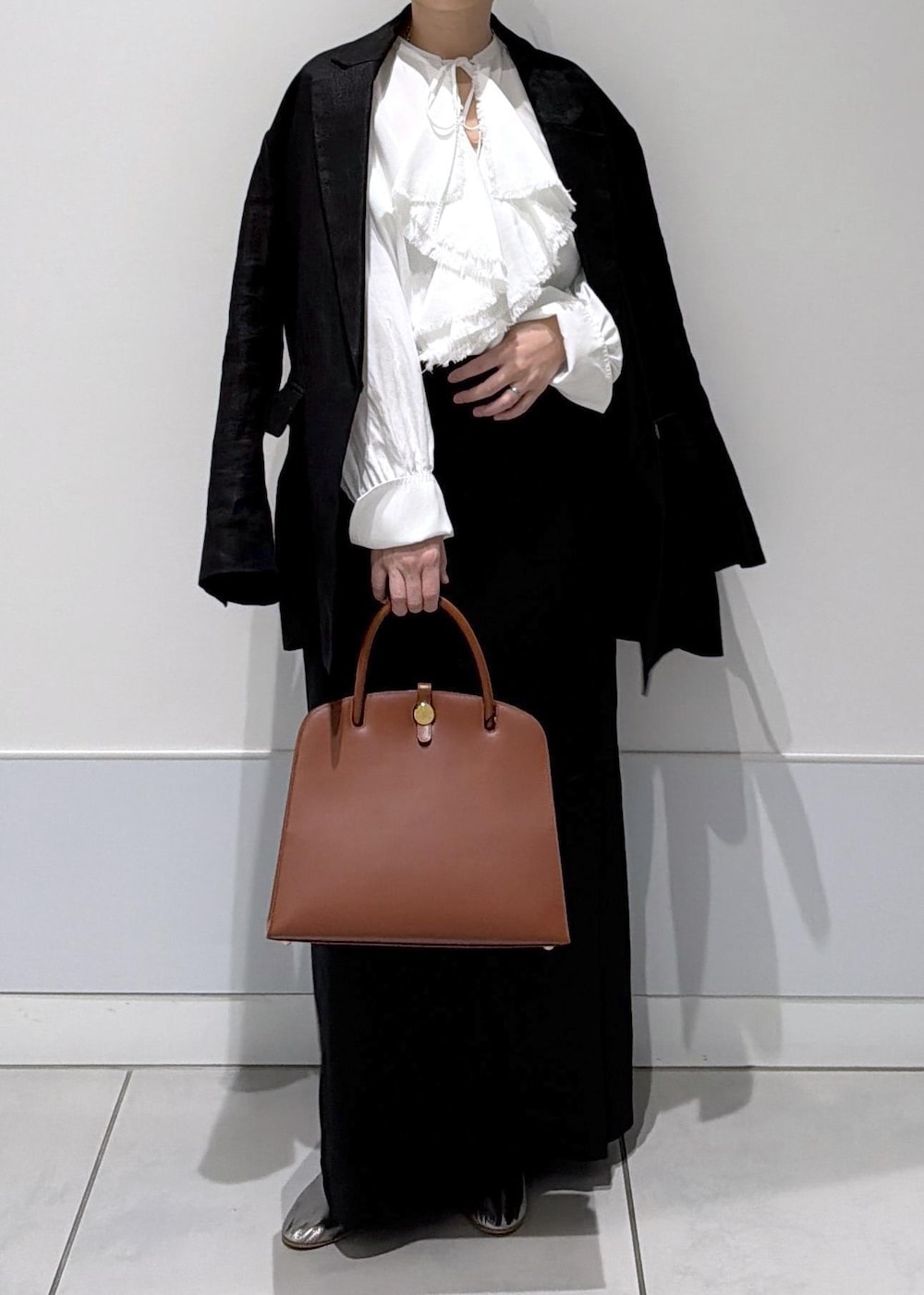 ブラック系のスカート、ブラック系のテーラードジャケット、ホワイト系のシャツ/ブラウスを着用したレディースの冬コーディネートの4枚目の写真