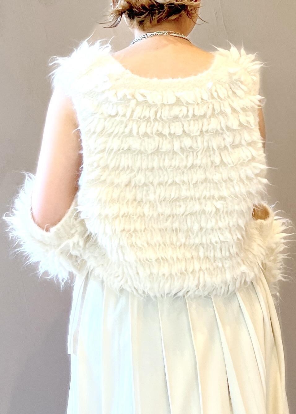 グレー系のショルダーバッグ、ホワイト系のベスト、ホワイト系のキャップを着用したレディースの秋コーディネートの7枚目の写真