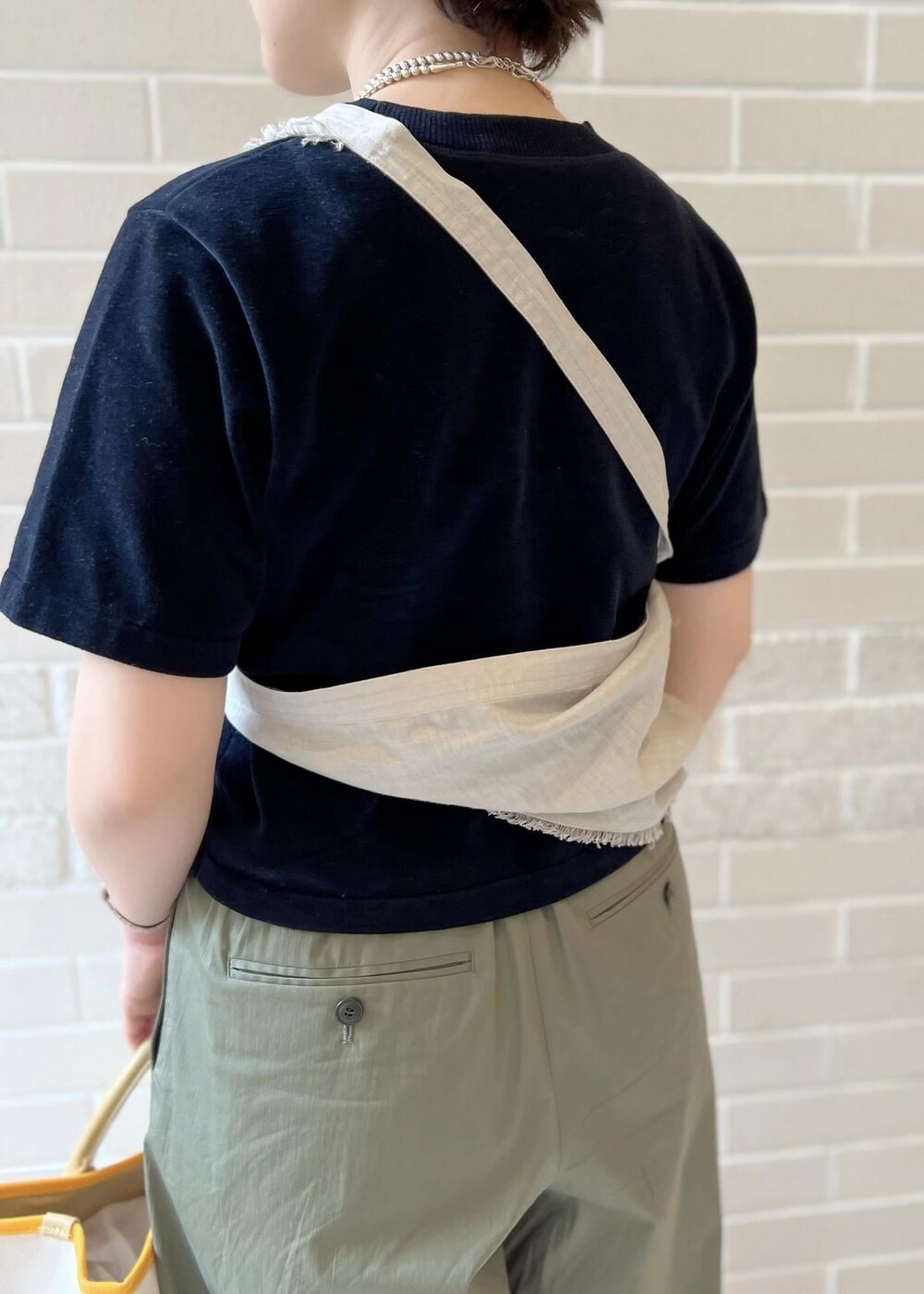 ホワイト系のトートバッグ、ブラック系のTシャツ/カットソー、グリーン系のその他パンツを着用したレディースの春コーディネートの7枚目の写真