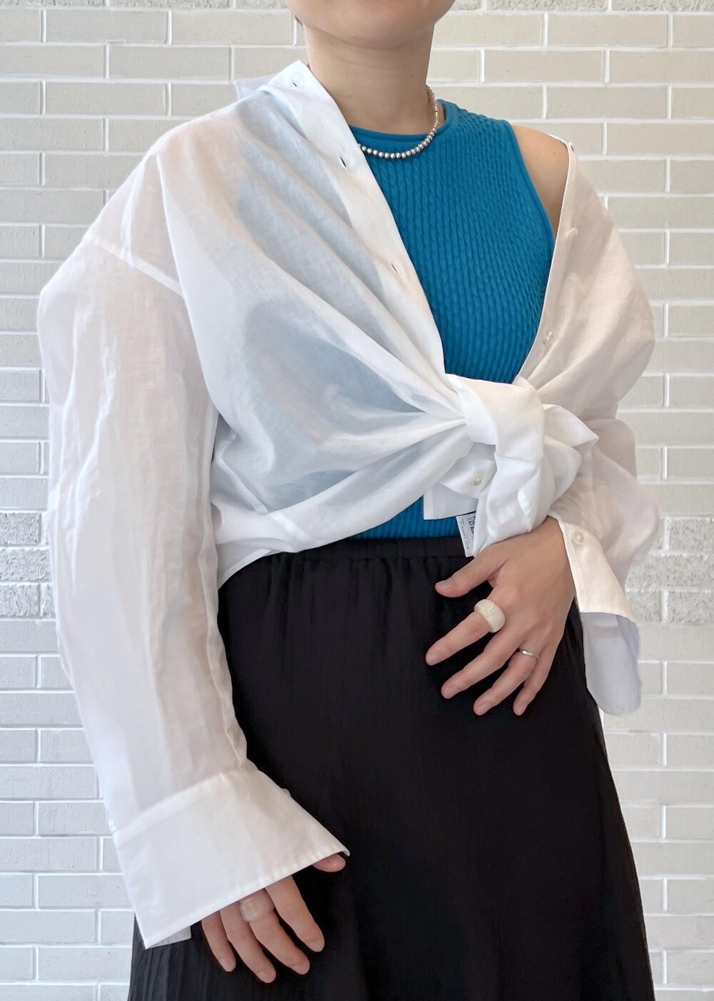 ブラック系のスカート、ホワイト系のシャツ/ブラウス、ブルー系のタンクトップを着用したレディースの夏コーディネートの6枚目の写真