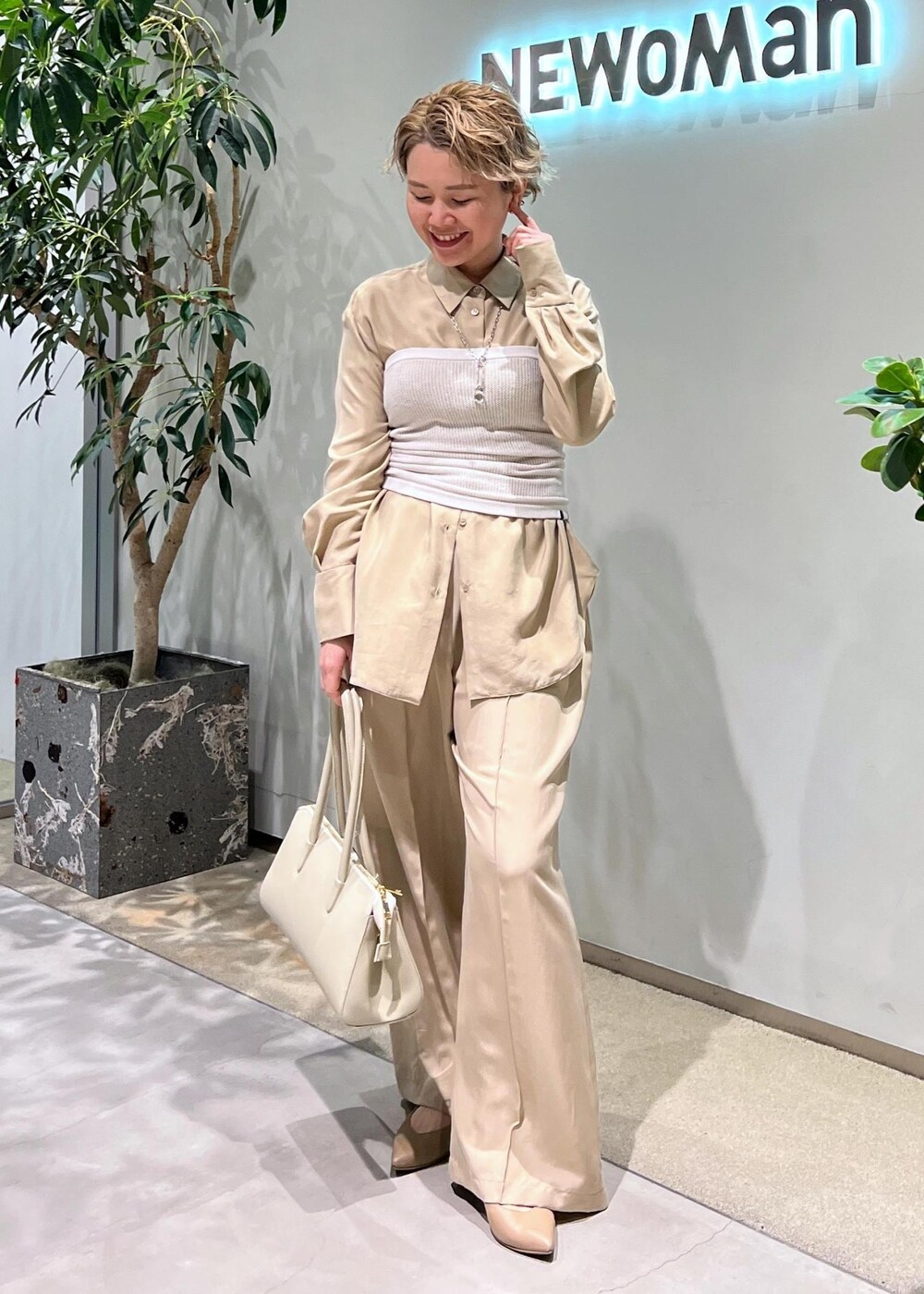 ベージュ系のその他パンツ、ベージュ系のシャツ/ブラウス、ホワイト系のボストンバッグを着用したレディースの春コーディネートの3枚目の写真