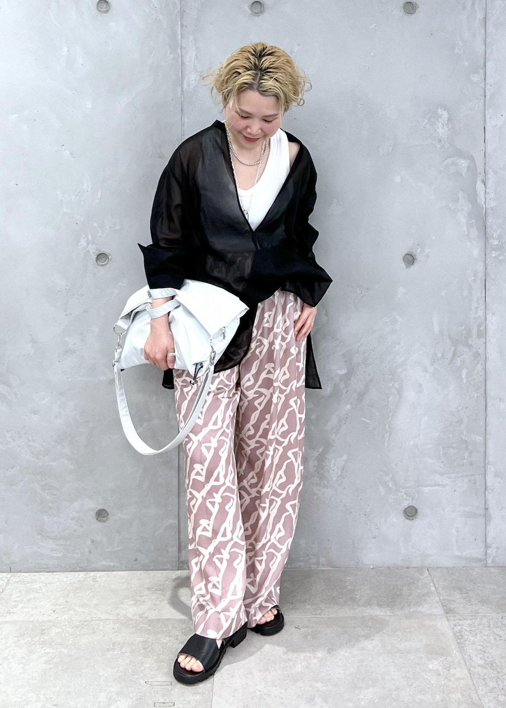 イエロー系のその他パンツ、ブラック系のシャツ/ブラウス、グレー系のトートバッグを着用したレディースの冬コーディネートの2枚目の写真