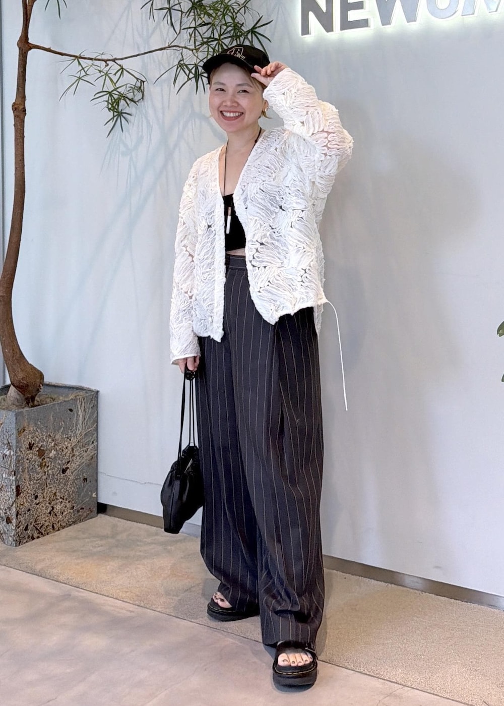 グレー系のその他パンツ、ブラック系のショルダーバッグ、ホワイト系のシャツ/ブラウスを着用したレディースの夏コーディネートの3枚目の写真