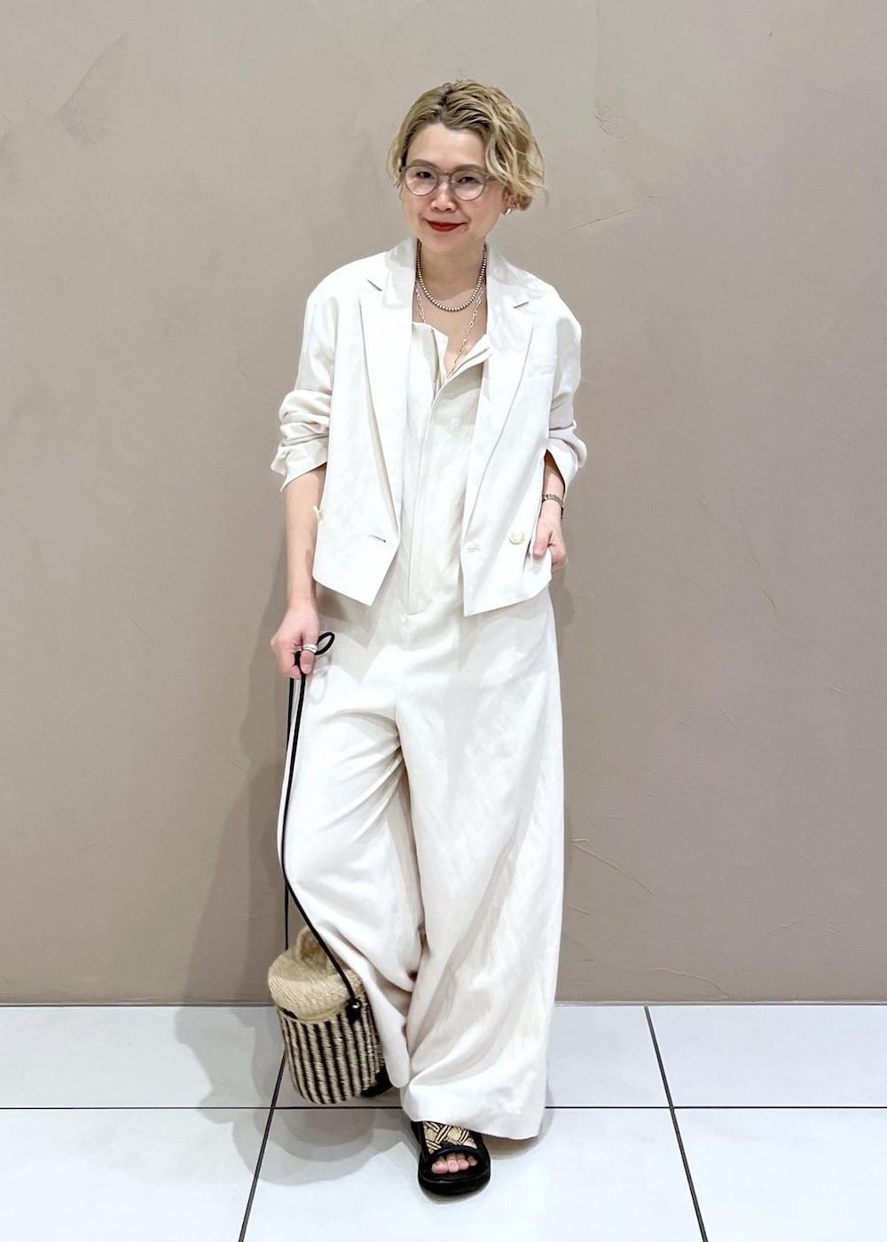 ホワイト系のテーラードジャケット、ホワイト系のつなぎ/オールインワン、ホワイト系のショルダーバッグを着用したレディースの春コーディネートの2枚目の写真