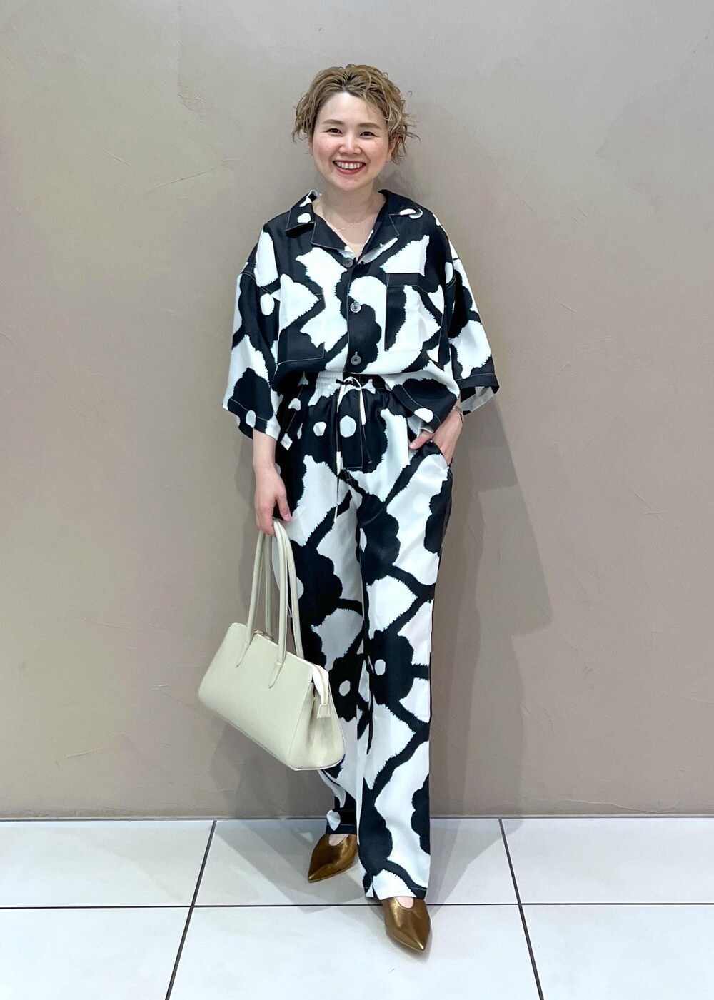 ホワイト系のボストンバッグ、その他のパンプス、ホワイト系のシャツ/ブラウスを着用したレディースの春コーディネートの3枚目の写真