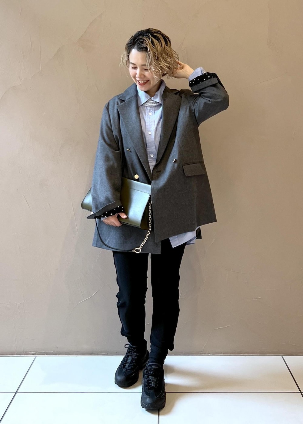 ブルー系のシャツ/ブラウス、グレー系のテーラードジャケット、グリーン系のショルダーバッグを着用したレディースの秋コーディネートの2枚目の写真