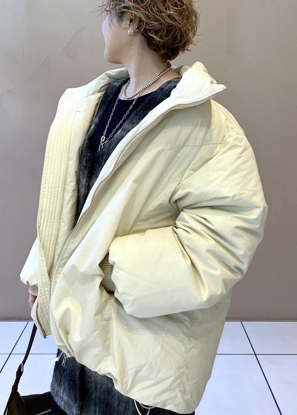 ホワイト系のダウンジャケット/コート、グレー系のジャンパースカート、ブラウン系のショルダーバッグを着用したレディースの秋コーディネートの9枚目の写真