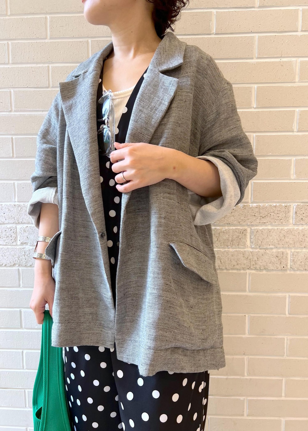 ホワイト系のタンクトップ、グリーン系のハンドバッグ、ブラック系のサンダルを着用したレディースの夏コーディネートの4枚目の写真