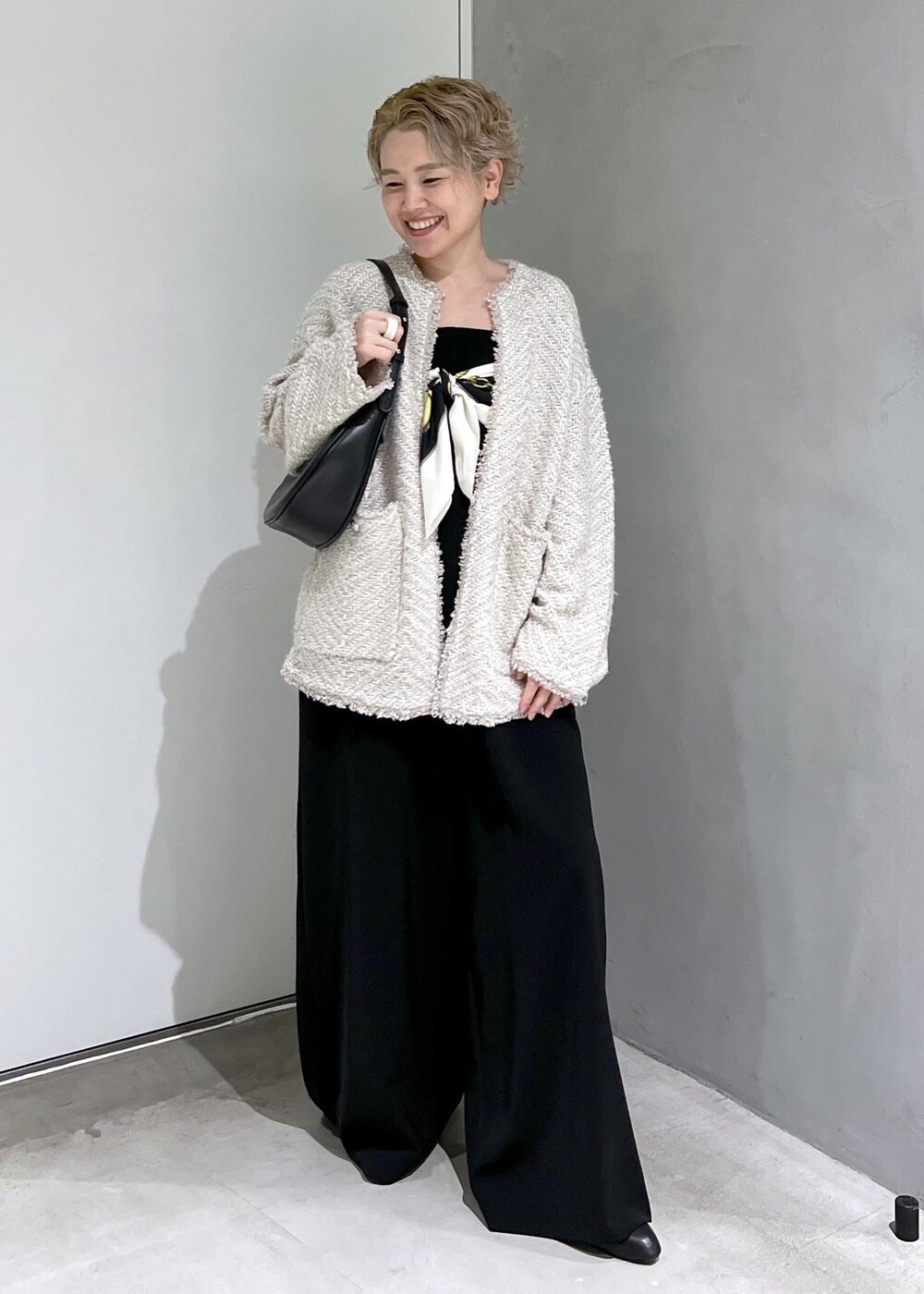 ブラック系のつなぎ/オールインワン、ベージュ系のカーディガン/ボレロ、ブラック系のブーツを着用したレディースの秋コーディネートの5枚目の写真