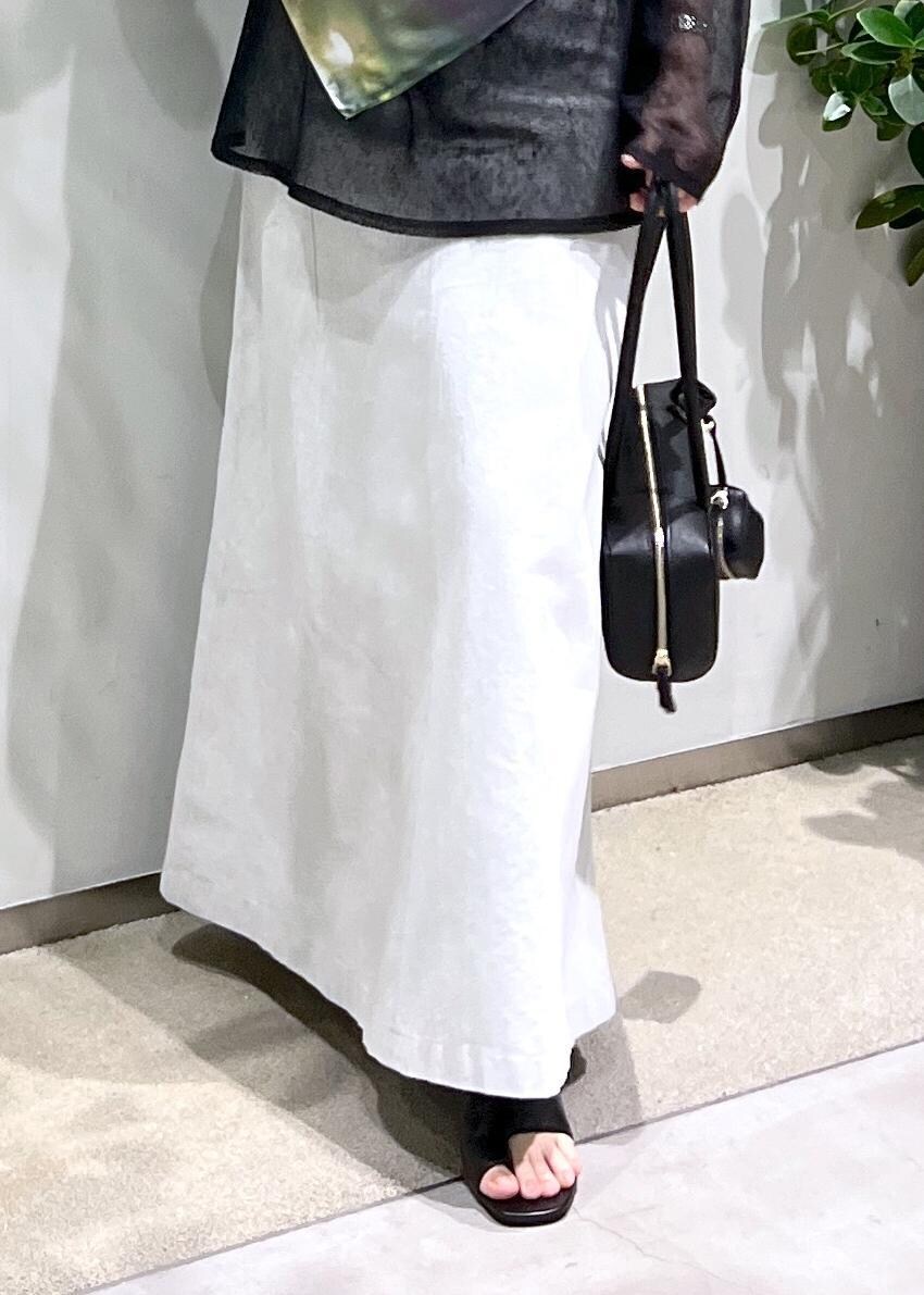 ホワイト系のスカート、ブラック系のサンダル、ブラック系のショルダーバッグを着用したレディースの夏コーディネートの6枚目の写真