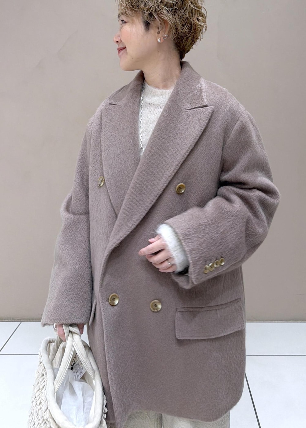 ベージュ系のパンプス、ブラウン系のチェスターコートを着用したレディースの冬コーディネートの8枚目の写真