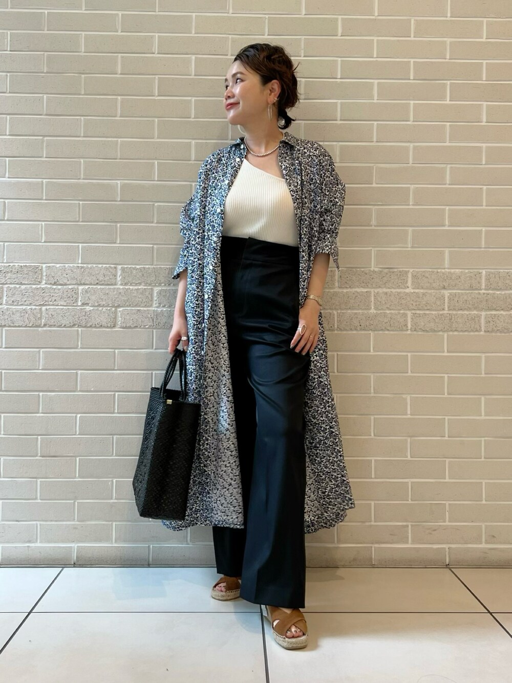 ブルー系のシャツワンピース、ホワイト系のトップス、ブラック系のその他パンツを着用したレディースの春コーディネートの2枚目の写真