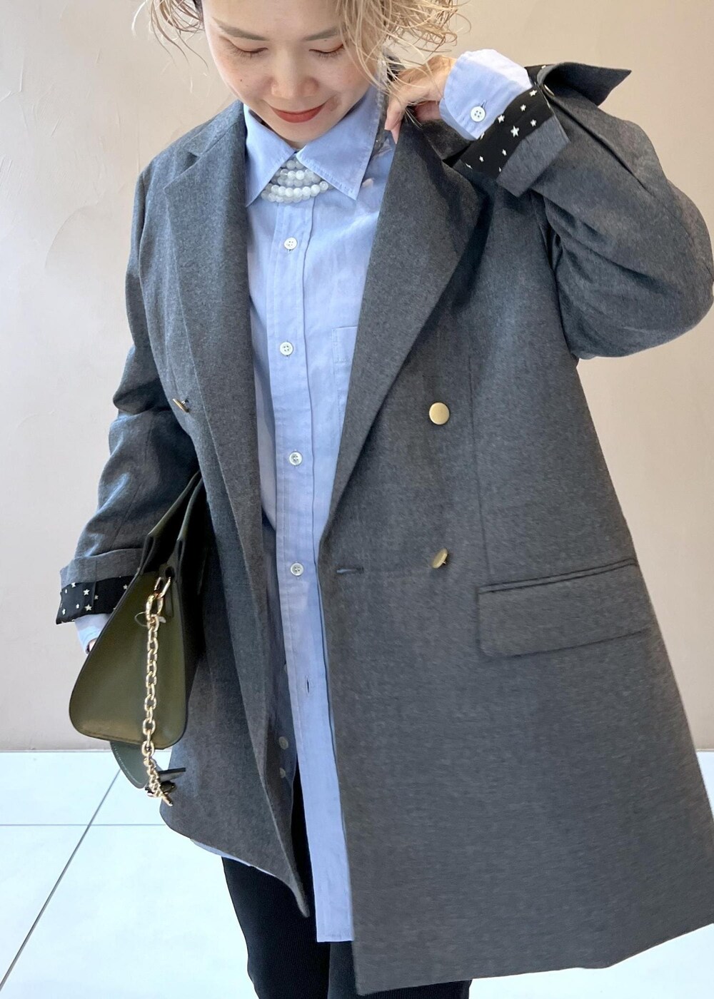 ブルー系のシャツ/ブラウス、グレー系のテーラードジャケット、グリーン系のショルダーバッグを着用したレディースの秋コーディネートの7枚目の写真