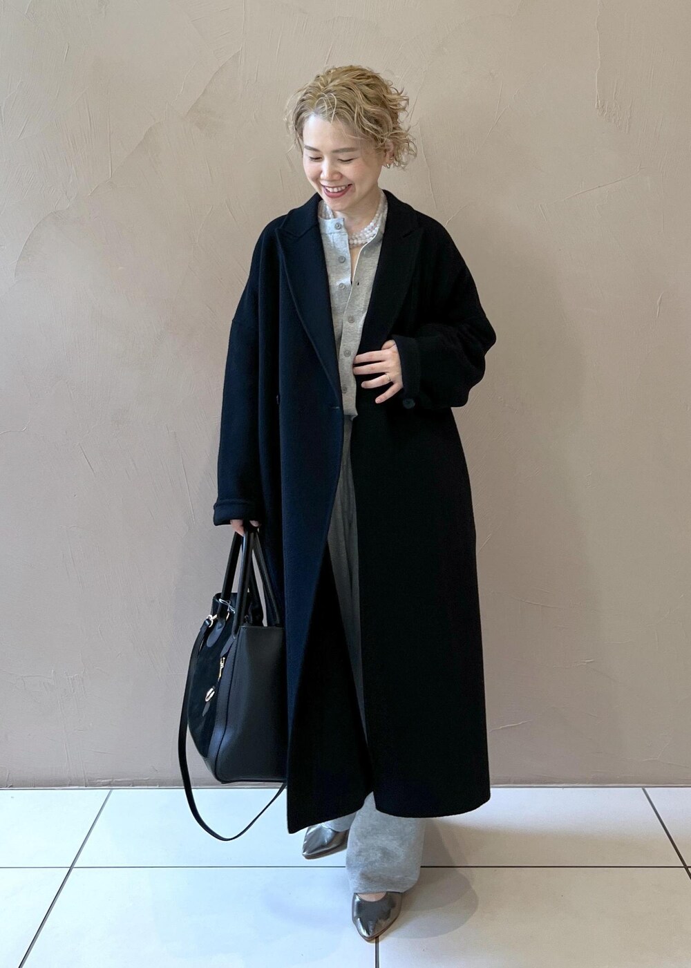 ブラック系のハンドバッグ、ブラック系のその他アウター、シルバー系のパンプスを着用したレディースの秋コーディネートの2枚目の写真