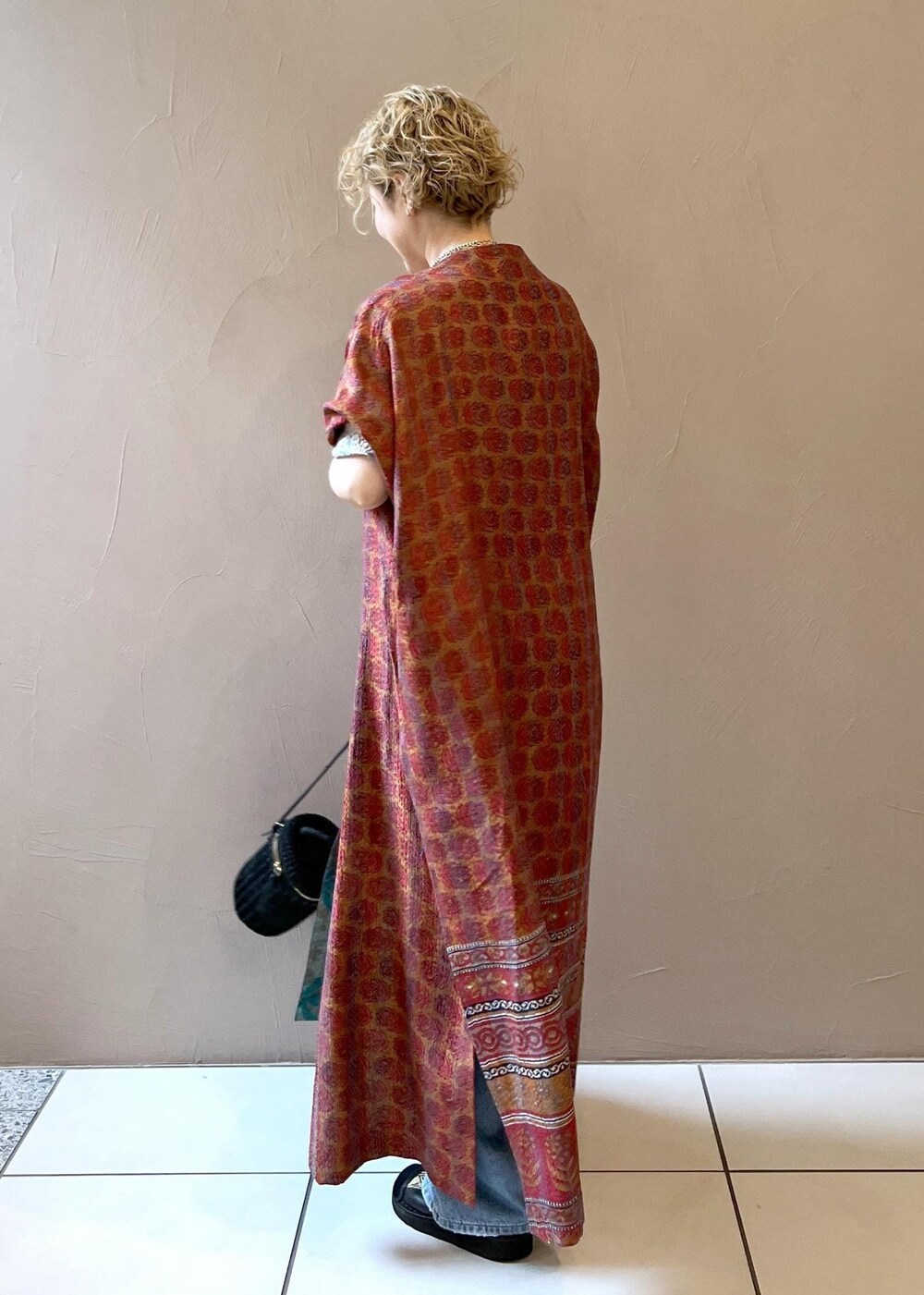 ブラック系のショルダーバッグ、ブラック系のタンクトップ、ブルー系のデニムスカートを着用したレディースの春コーディネートの7枚目の写真