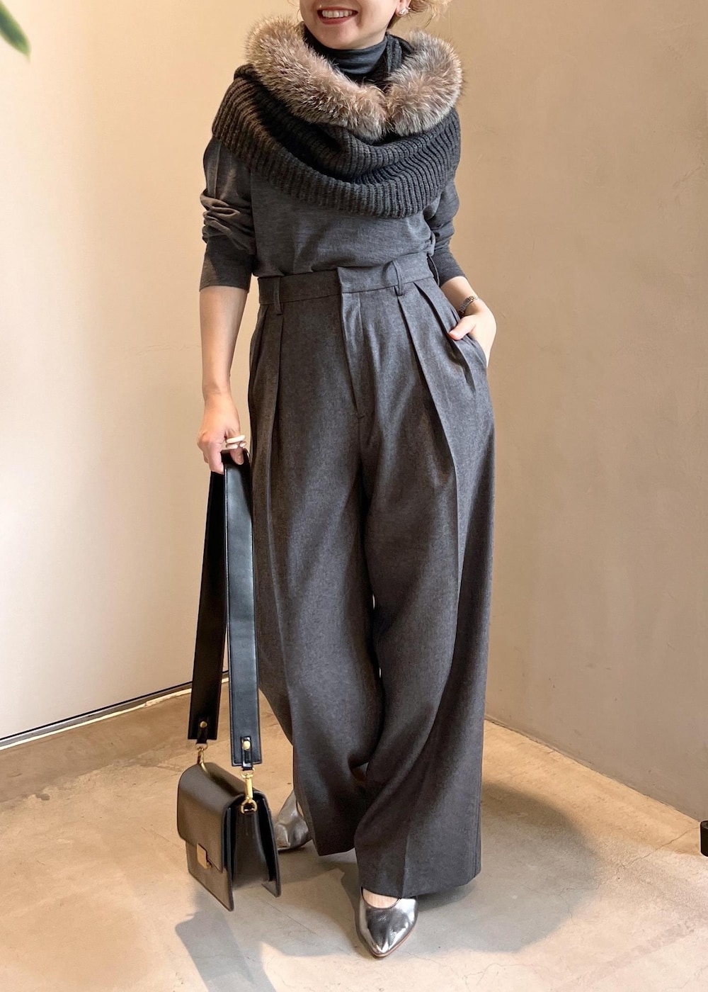 ブラック系のショルダーバッグ、グレー系のニット/セーター、グレー系のスラックスを着用したレディースの秋コーディネートの4枚目の写真