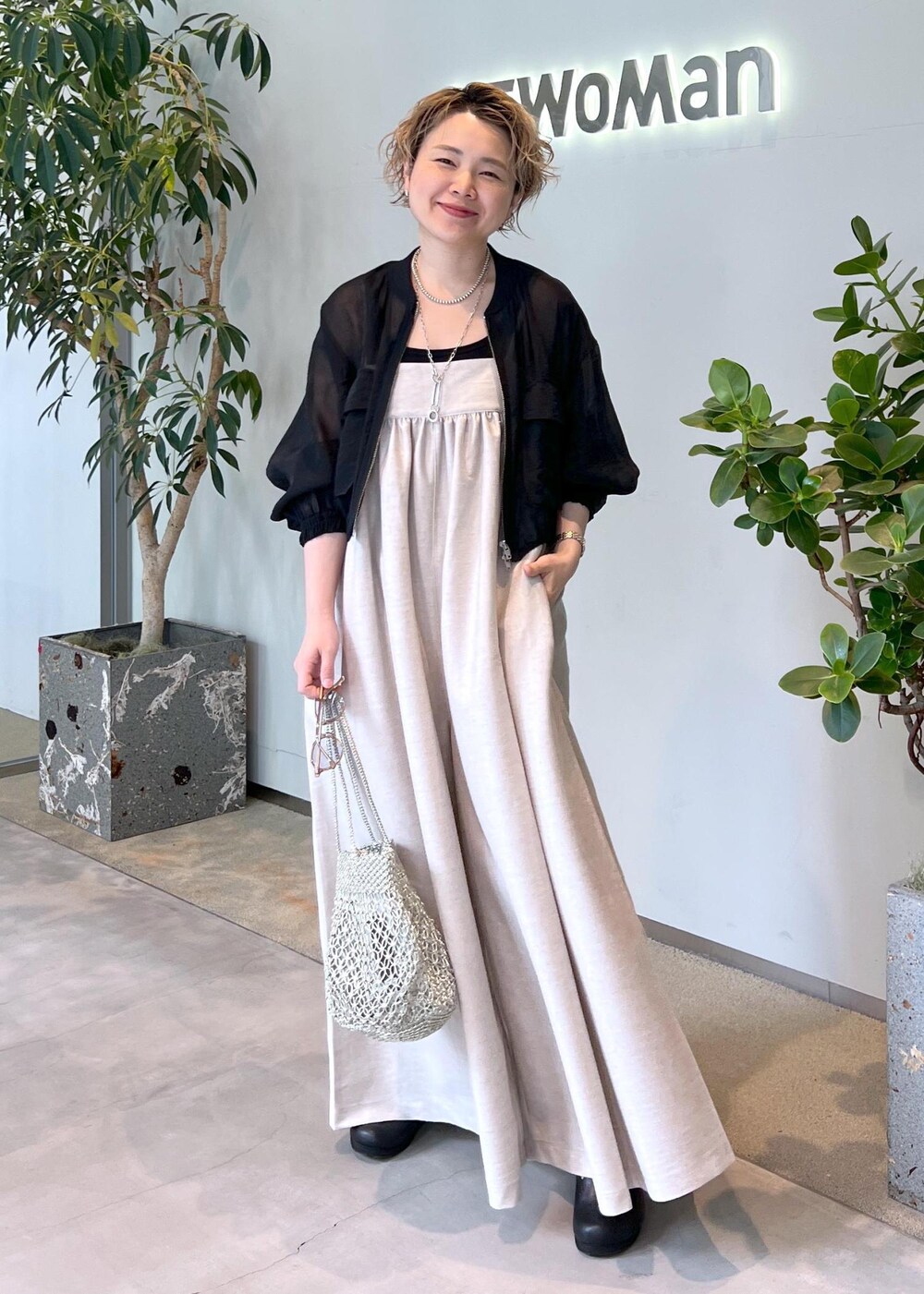 ブラック系のブルゾン、ブラック系のタンクトップ、シルバー系のトートバッグを着用したレディースの春コーディネートの3枚目の写真