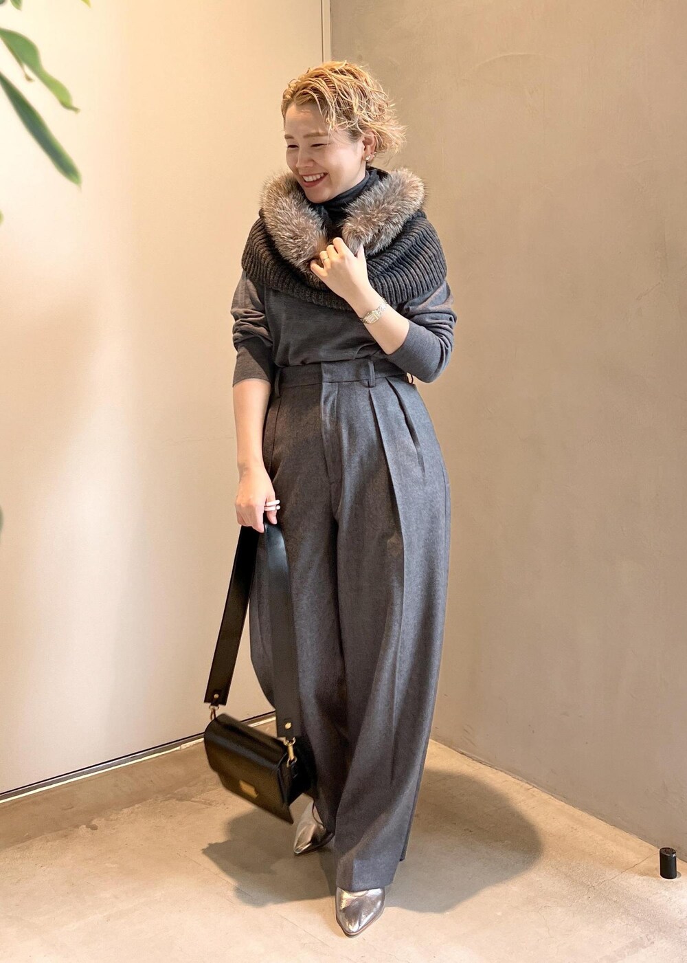 ブラック系のショルダーバッグ、グレー系のニット/セーター、グレー系のスラックスを着用したレディースの秋コーディネートの3枚目の写真