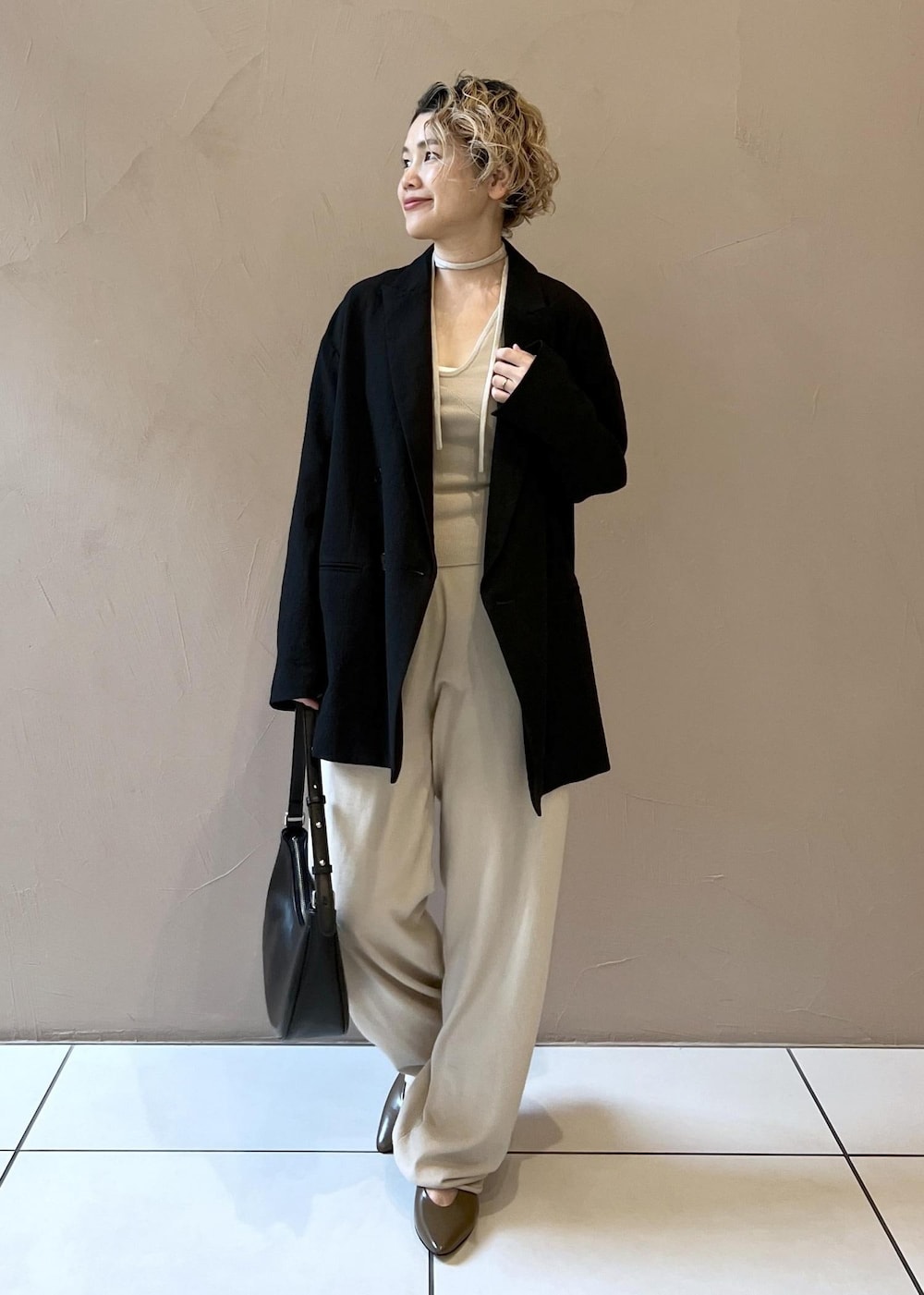 ブラック系のテーラードジャケット、ブラウン系のパンプスを着用したレディースの秋コーディネートの3枚目の写真