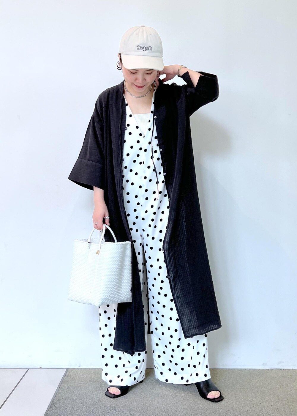 ホワイト系のつなぎ/オールインワン、ホワイト系のかごバッグ、ブラック系のシャツ/ブラウスを着用したレディースの夏コーディネートの3枚目の写真