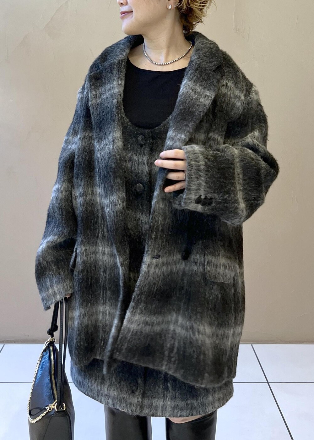 グレー系のジャンパースカート、グレー系のその他アウター、ブラック系のTシャツ/カットソーを着用したレディースの秋コーディネートの7枚目の写真