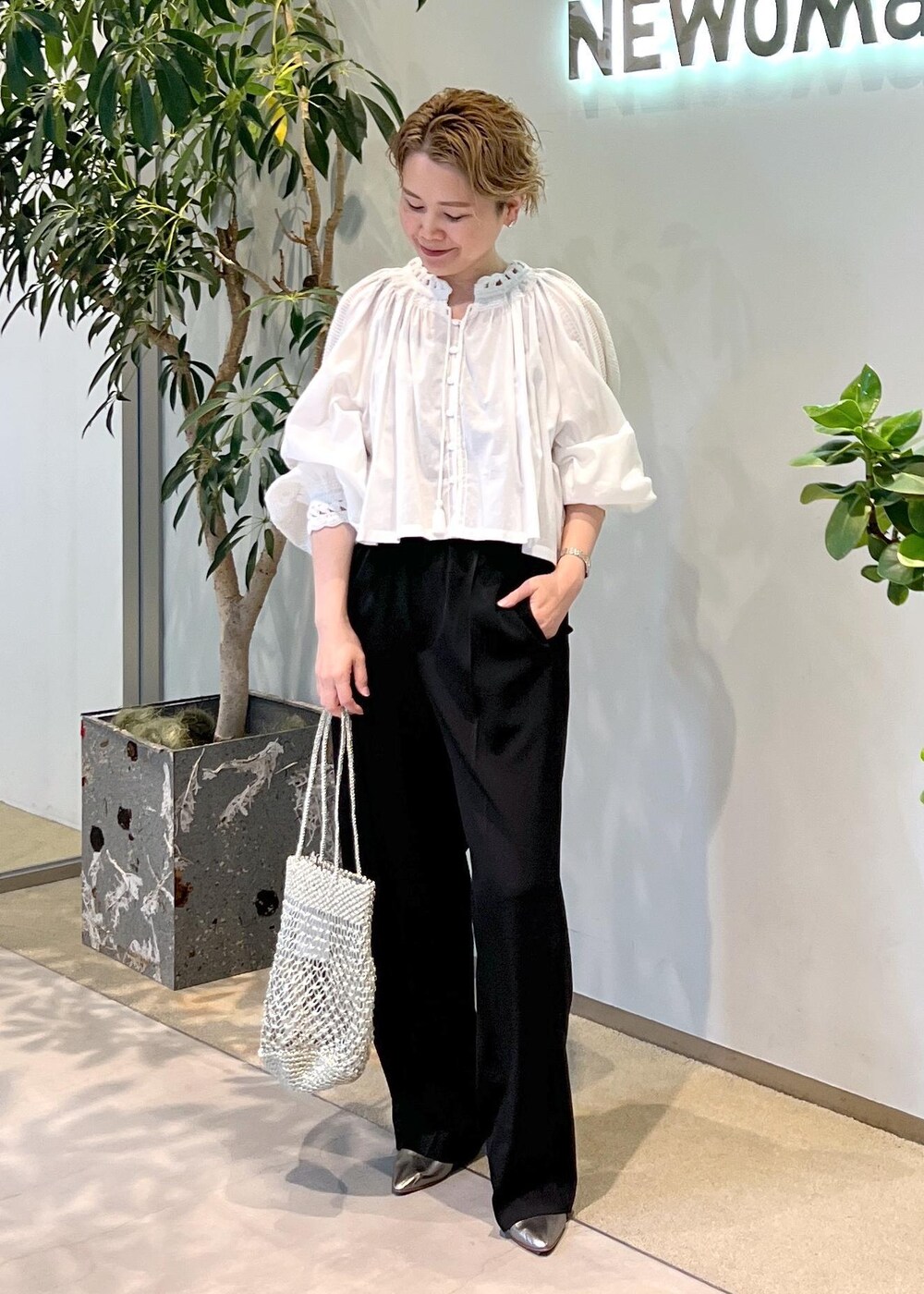 ブラック系のその他パンツ、シルバー系のトートバッグ、ホワイト系のシャツ/ブラウスを着用したレディースの夏コーディネートの4枚目の写真